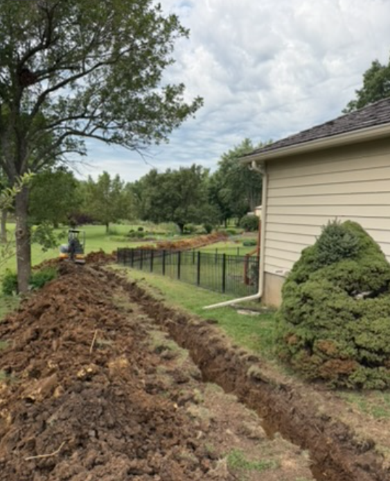 Open trench beside a home for a sewer line repair in Northeast Kansas