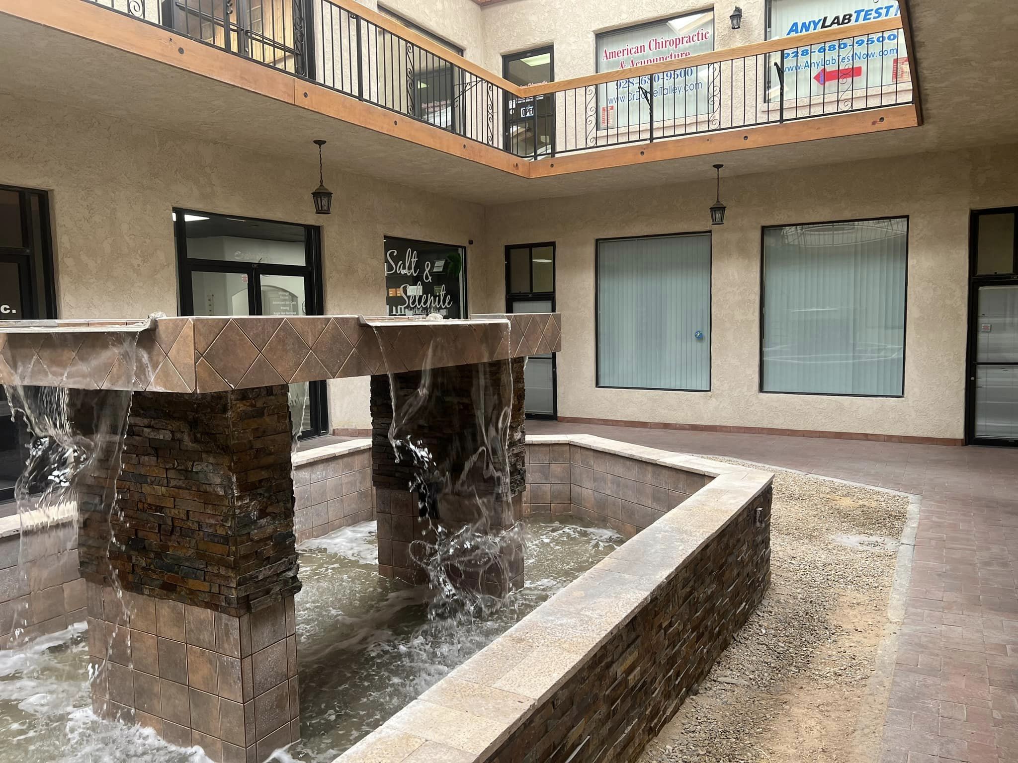 Peaceful stone courtyard waterfall fountain with cascading water outside the Salt and Selenite entrance