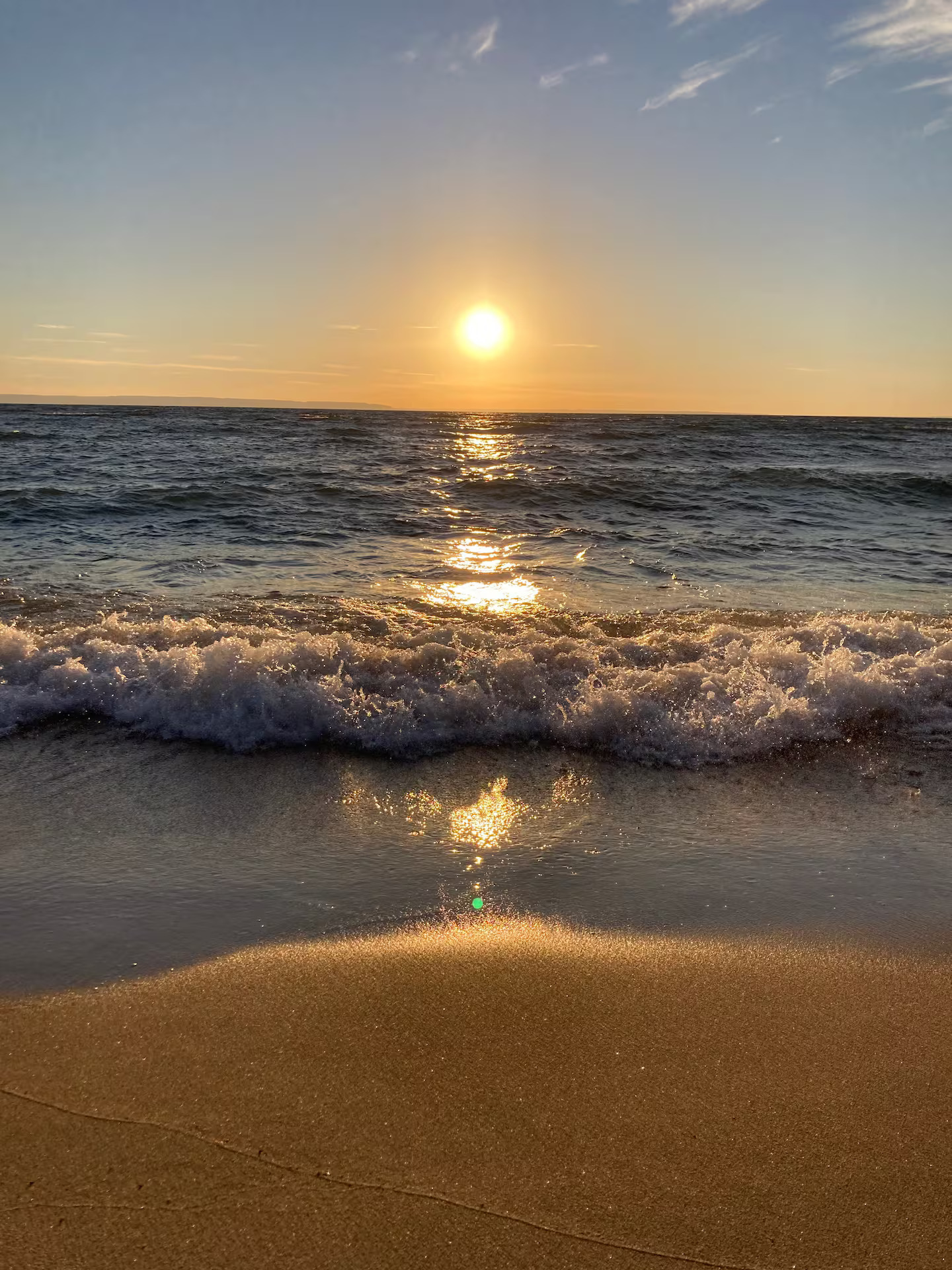 Golden sunset over the gentle waves and sandy shoreline of Georgian Bay