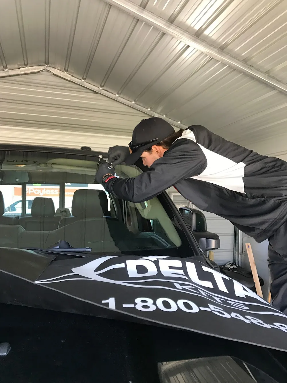 Technician repairing a rock chip on a car windshield