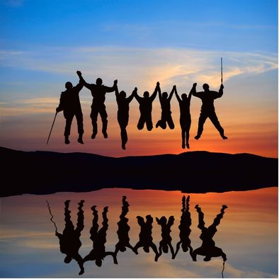 Silhouettes of friends joyfully jumping together against a twilight sunset and reflective lake