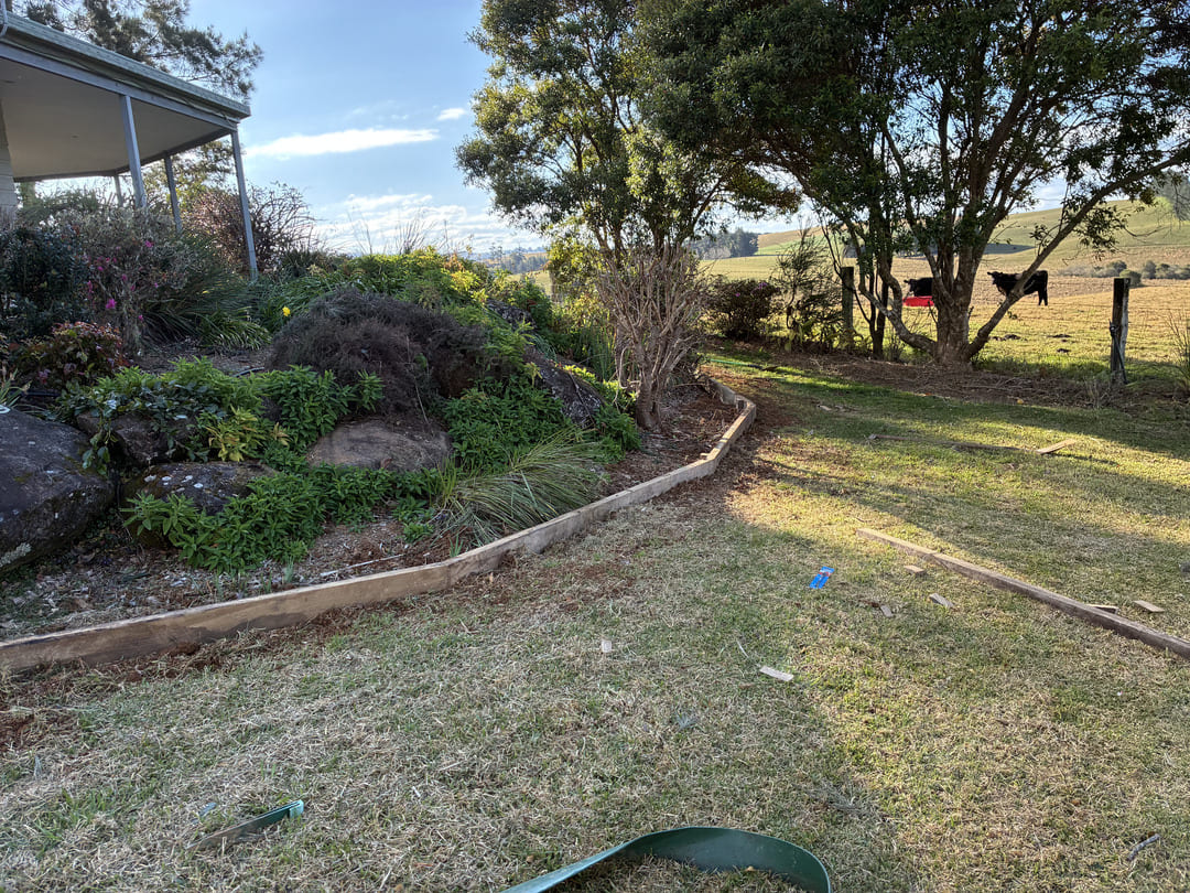 Timber garden edging around rockery and garden bed