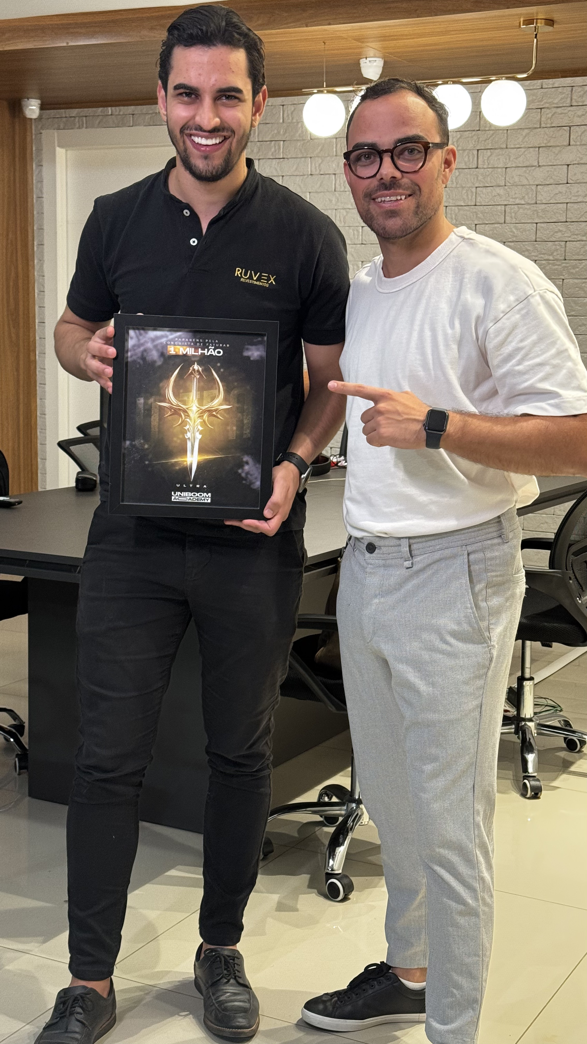 Fábio Henrique entregando placa de conquista de faturamento a cliente Uniboom