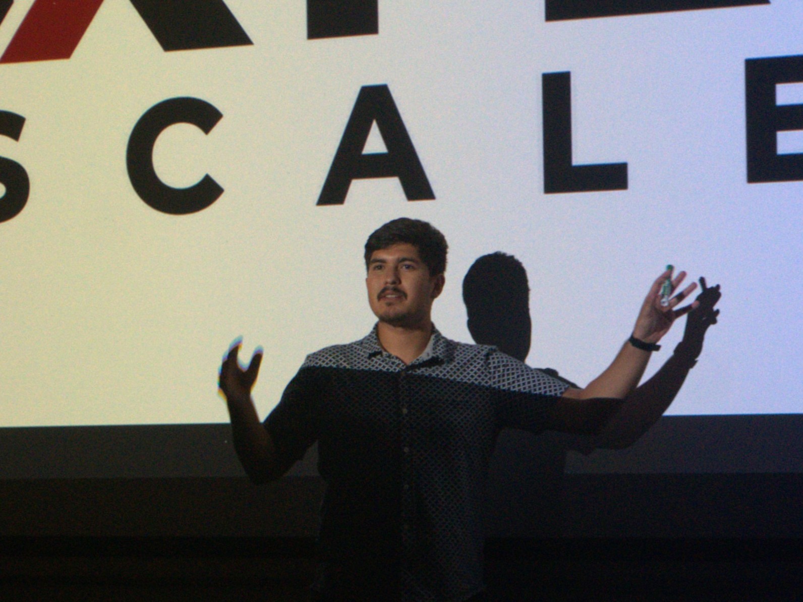 Alick Sandoval, founder of NXT LVL SCALES, in front of the agency logo