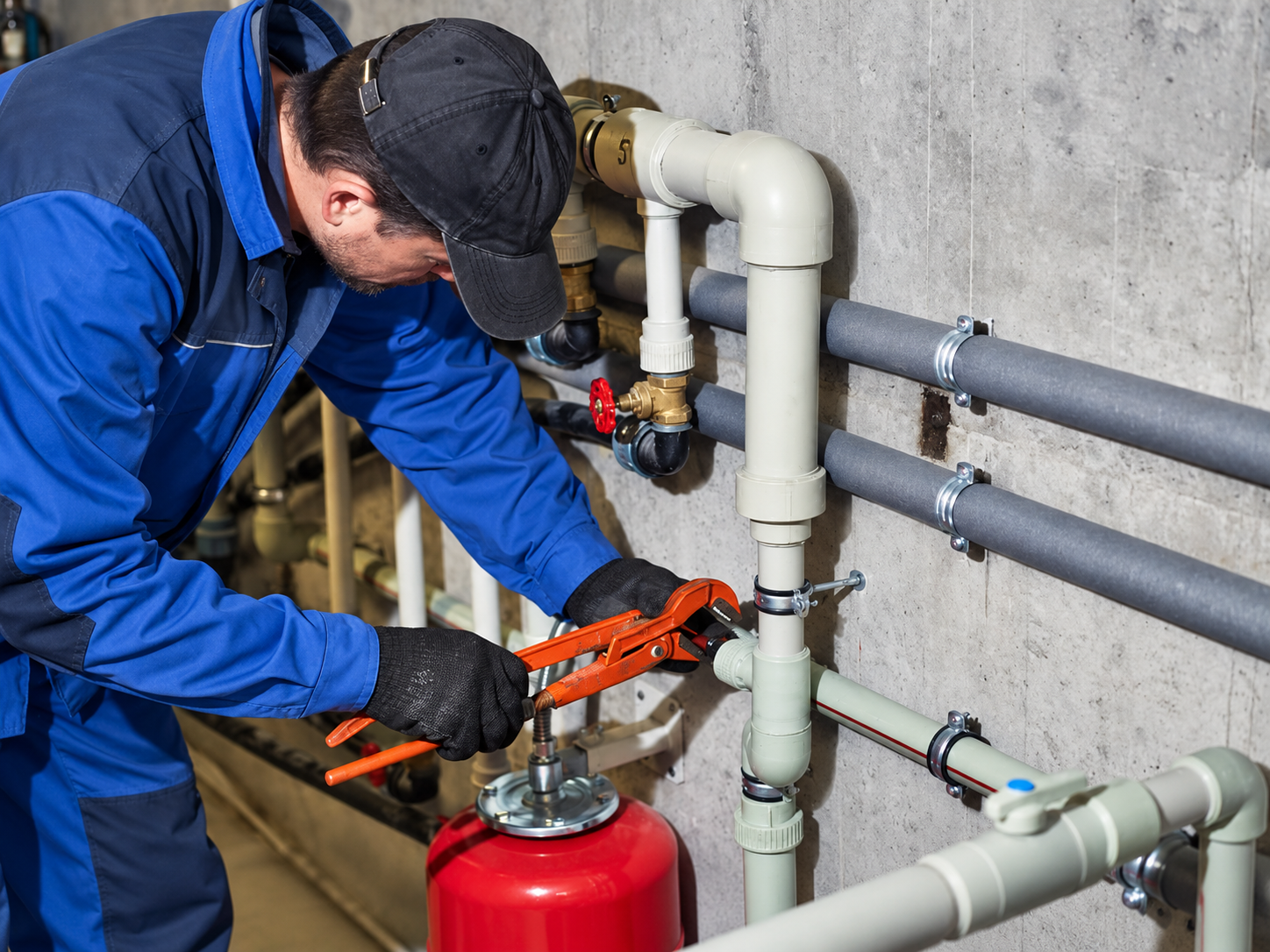 Licensed plumbing technician precision-servicing pressure tank and pipe fittings