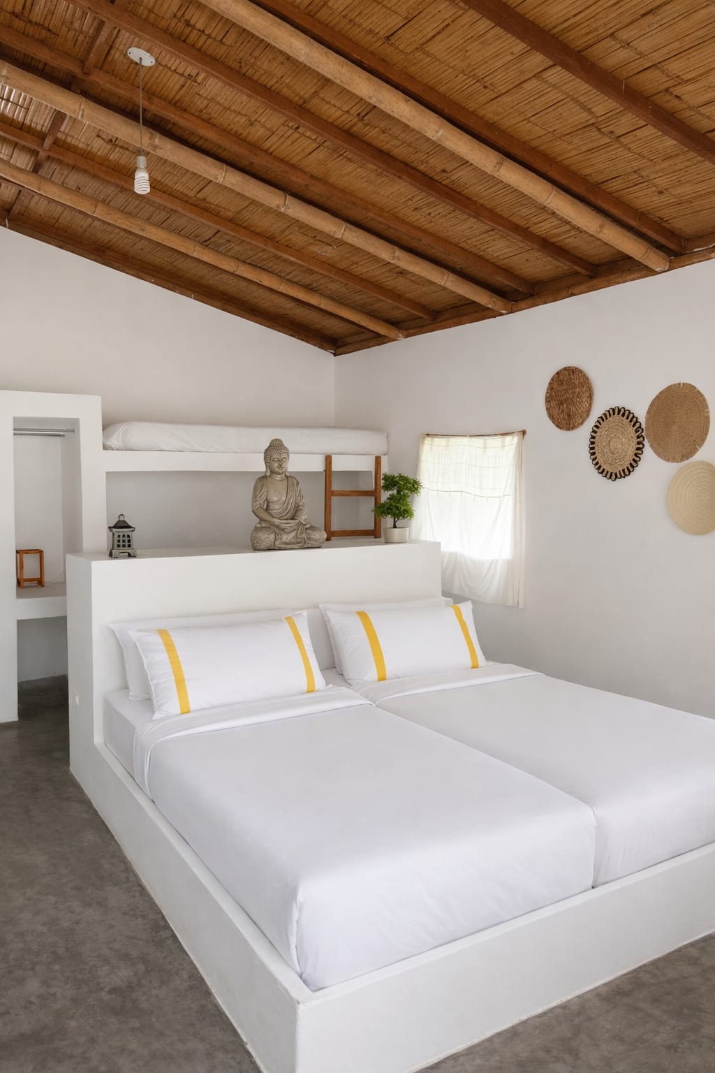 Java Suite at Bali Lodge Hotel — sleeps 4 room with crisp white beds, meditating Buddha on headboard, upper bunk, woven wall art, and pitched bamboo ceiling