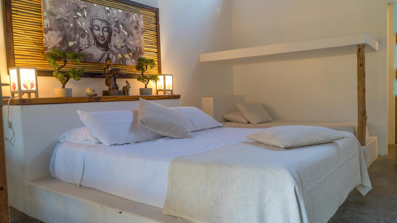 Padang Suite at Bali Lodge Hotel — sleeps 4 family room with main bed, built-in bed nook, Buddha artwork, bonsai, and warm lanterns