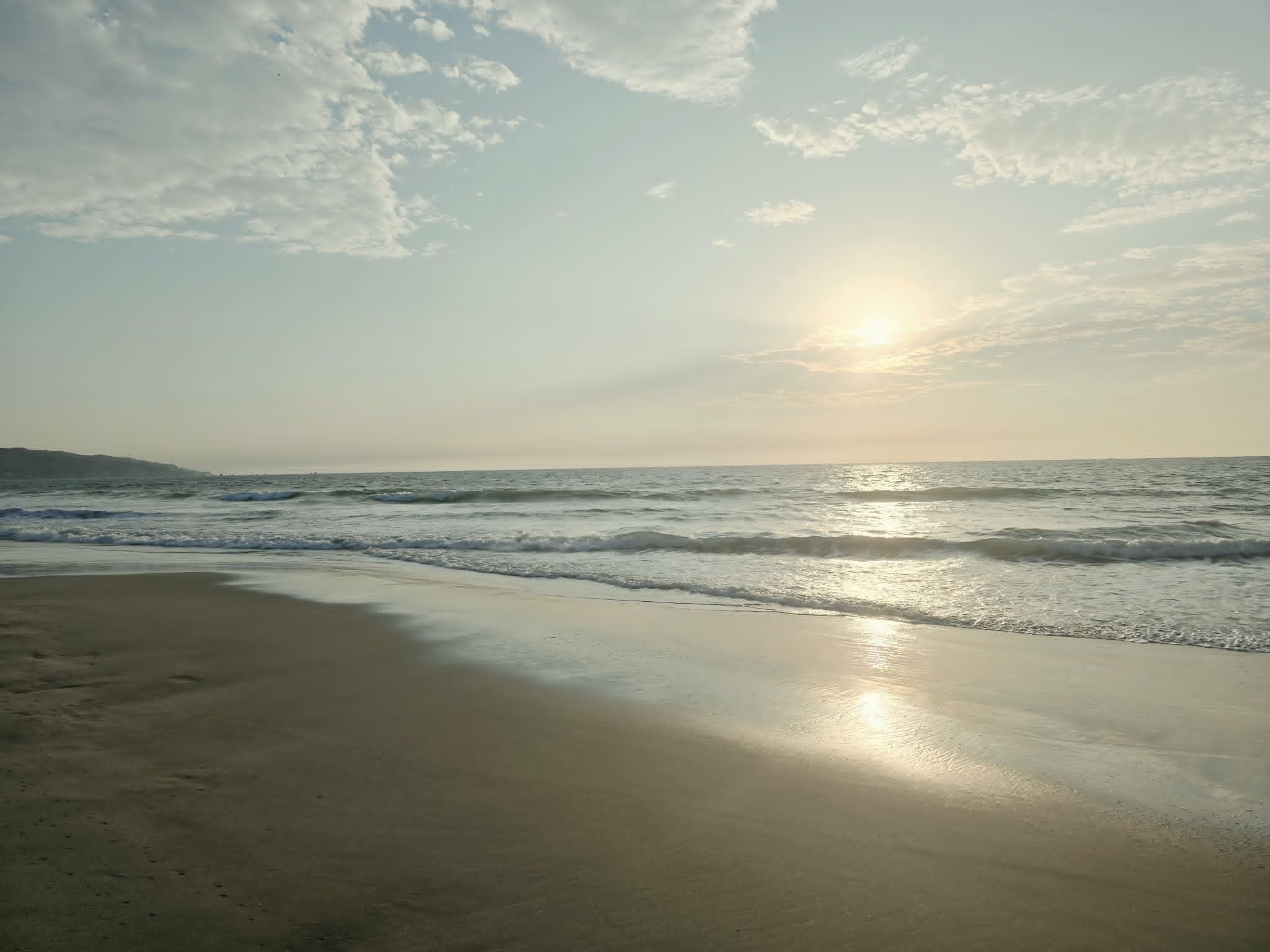Máncora Beach at sunset with glowing golden reflections across the Pacific waves and warm sand