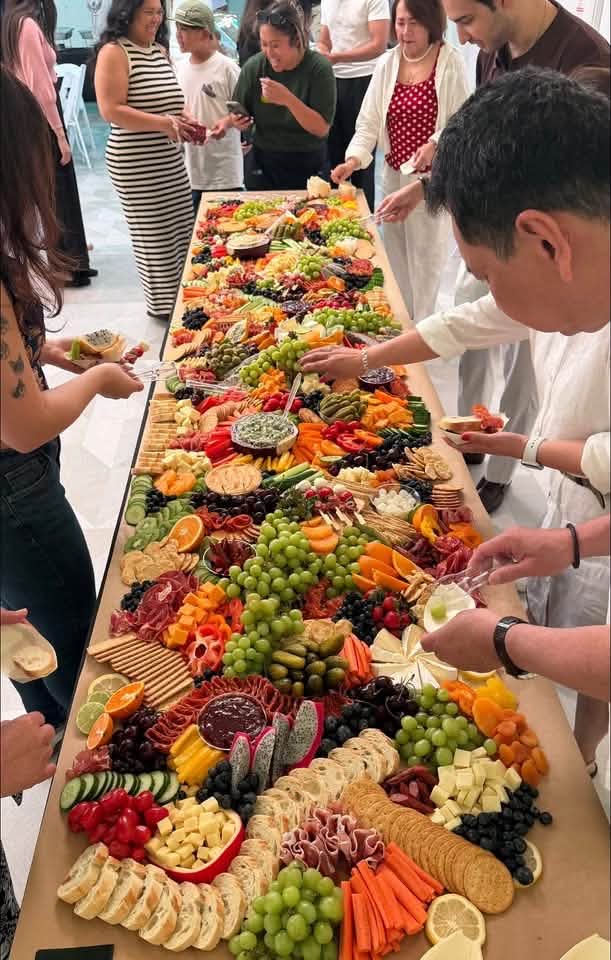 A diverse group of friends enjoying a charcuterie spread together