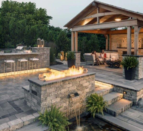 Concrete paver patio arranged around a fire feature with covered seating nearby, installed by a concrete contractor in Casas Adobes, AZ