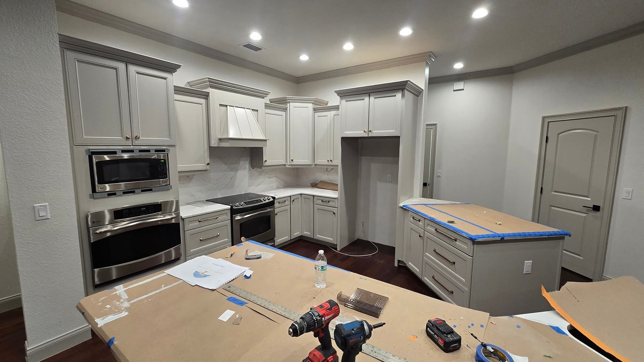 Painted custom kitchen cabinets with modern hardware during final reassembly
