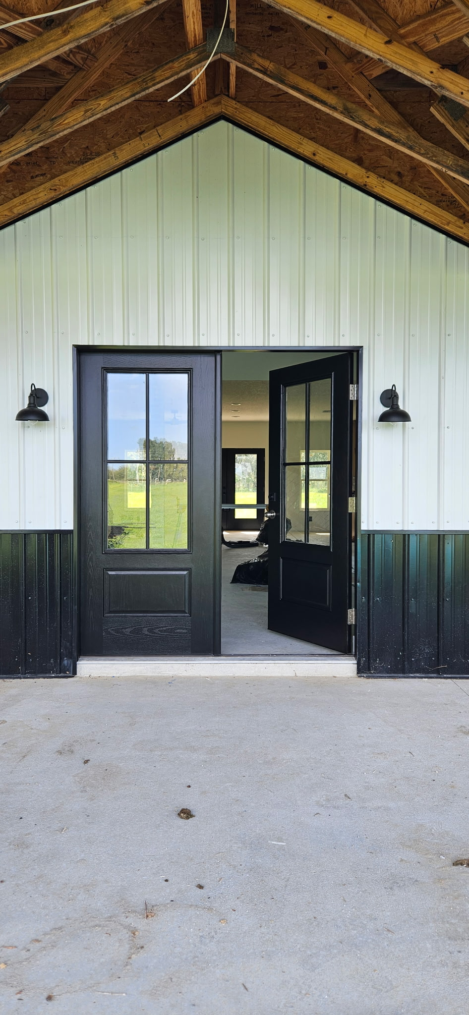 Completed satin black double entry doors with glass panes and exterior lighting