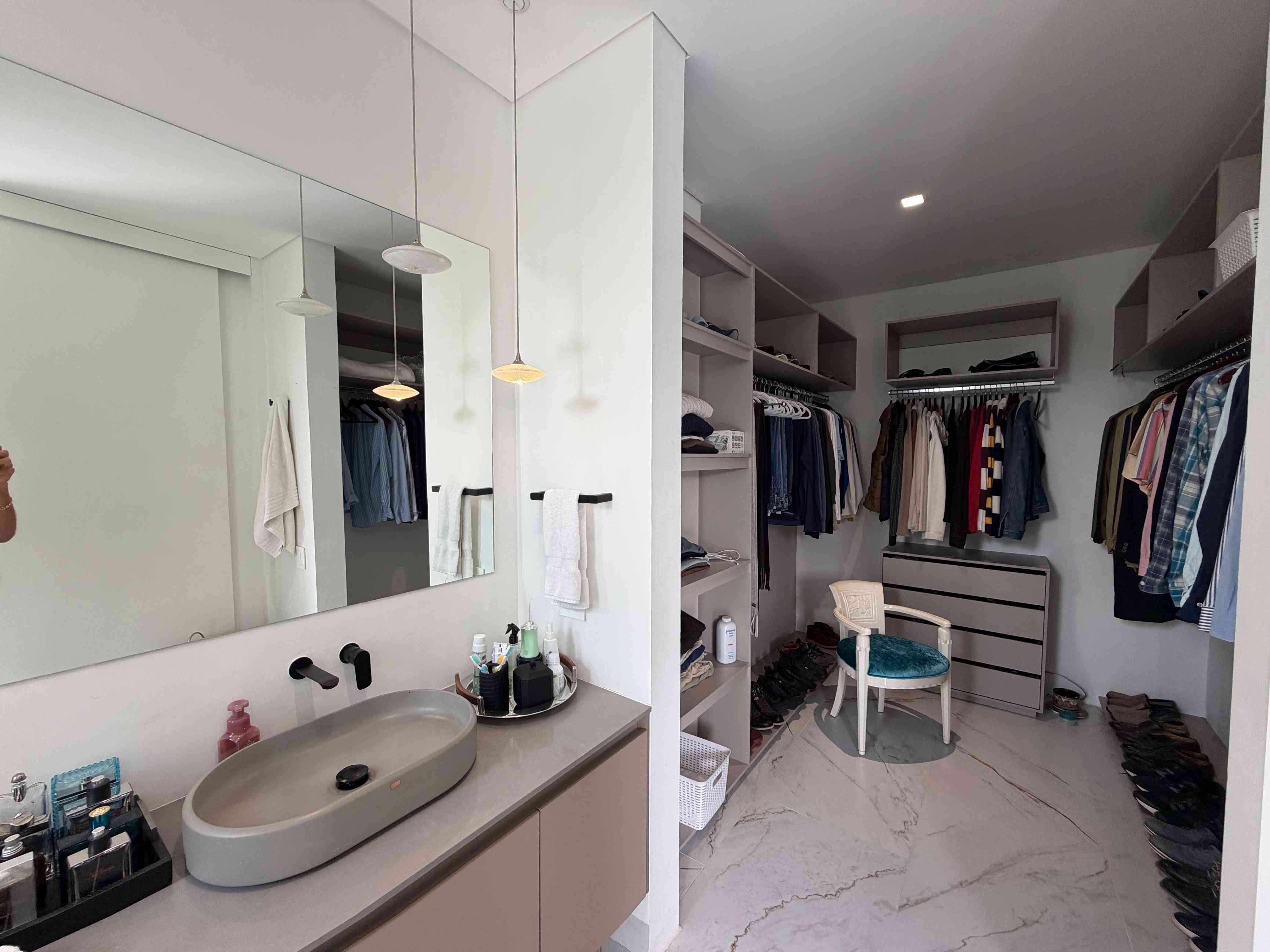 Vestidor walk-in closet y lavamanos de diseño en la suite principal