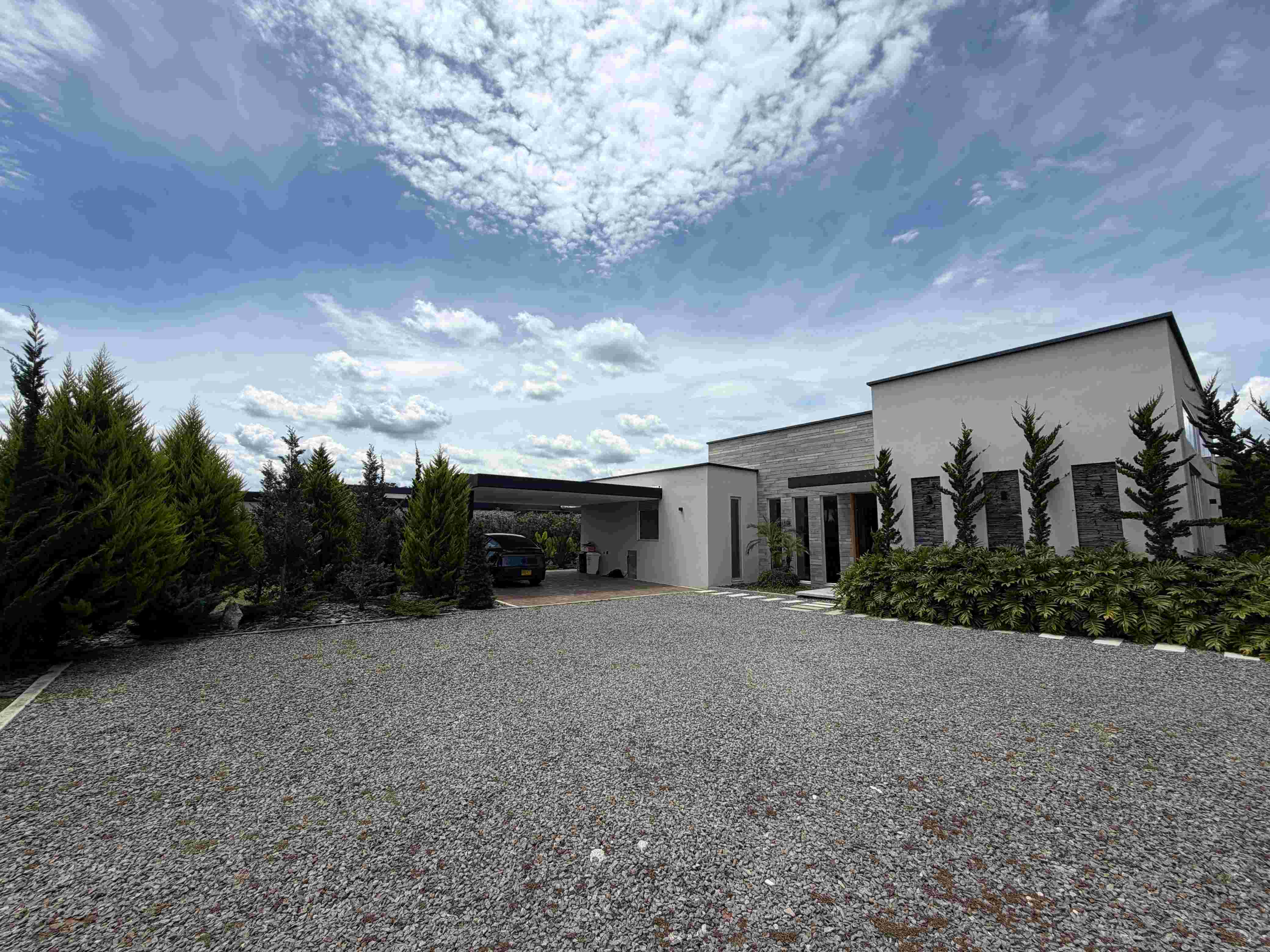 Fachada exterior contemporánea, acceso vehicular privado y parqueadero cubierto