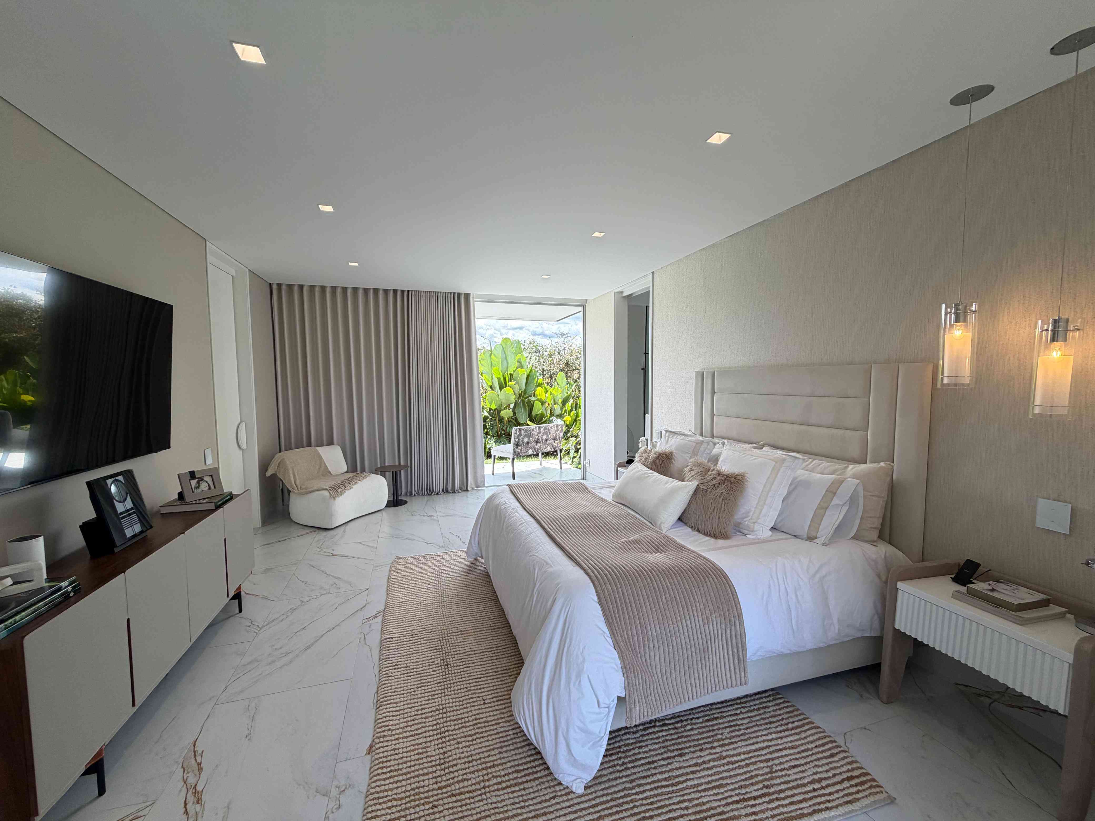 Suite principal con puerta corrediza hacia terraza privada y jardín