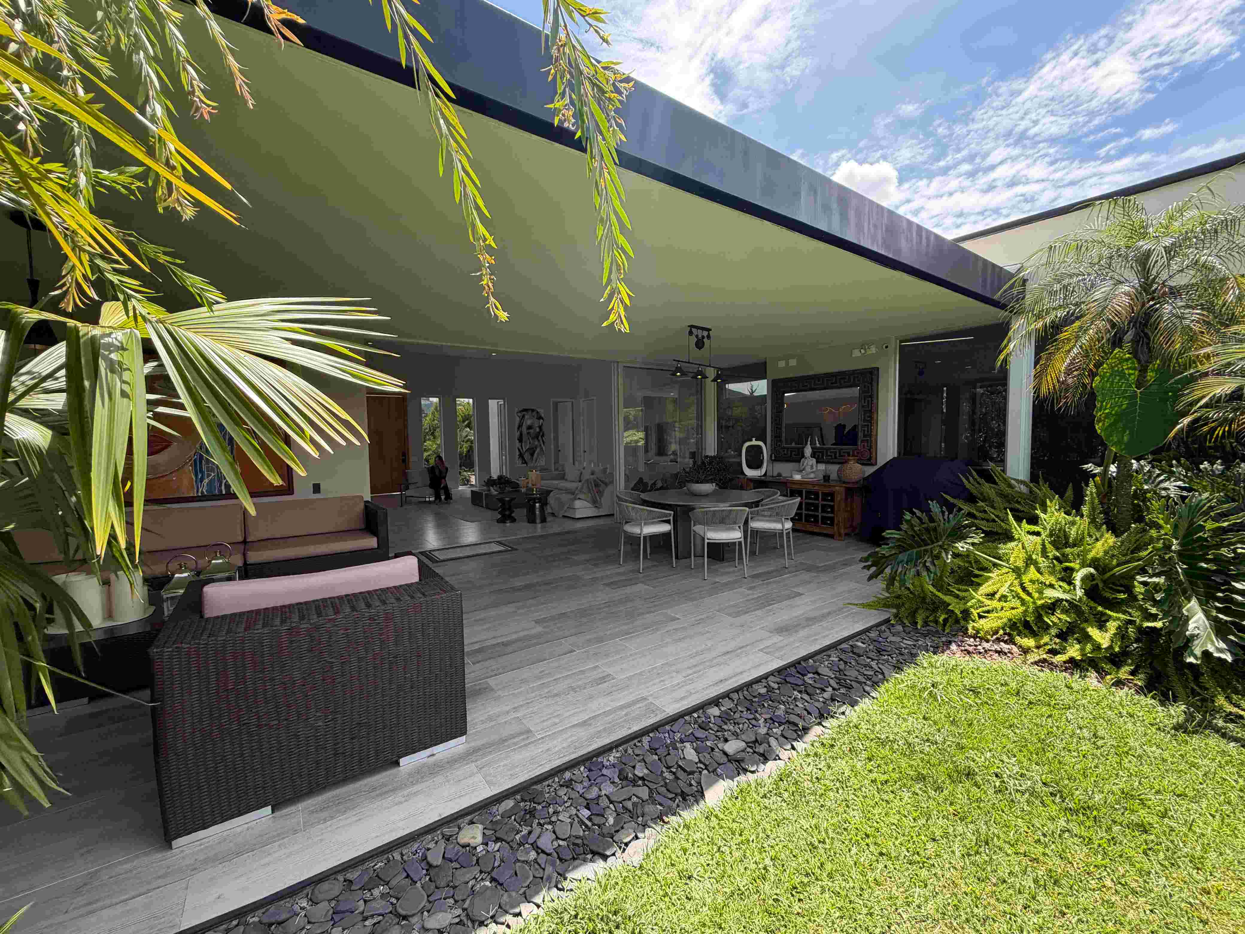 Gran terraza exterior cubierta y comedor al aire libre con vista a los jardines