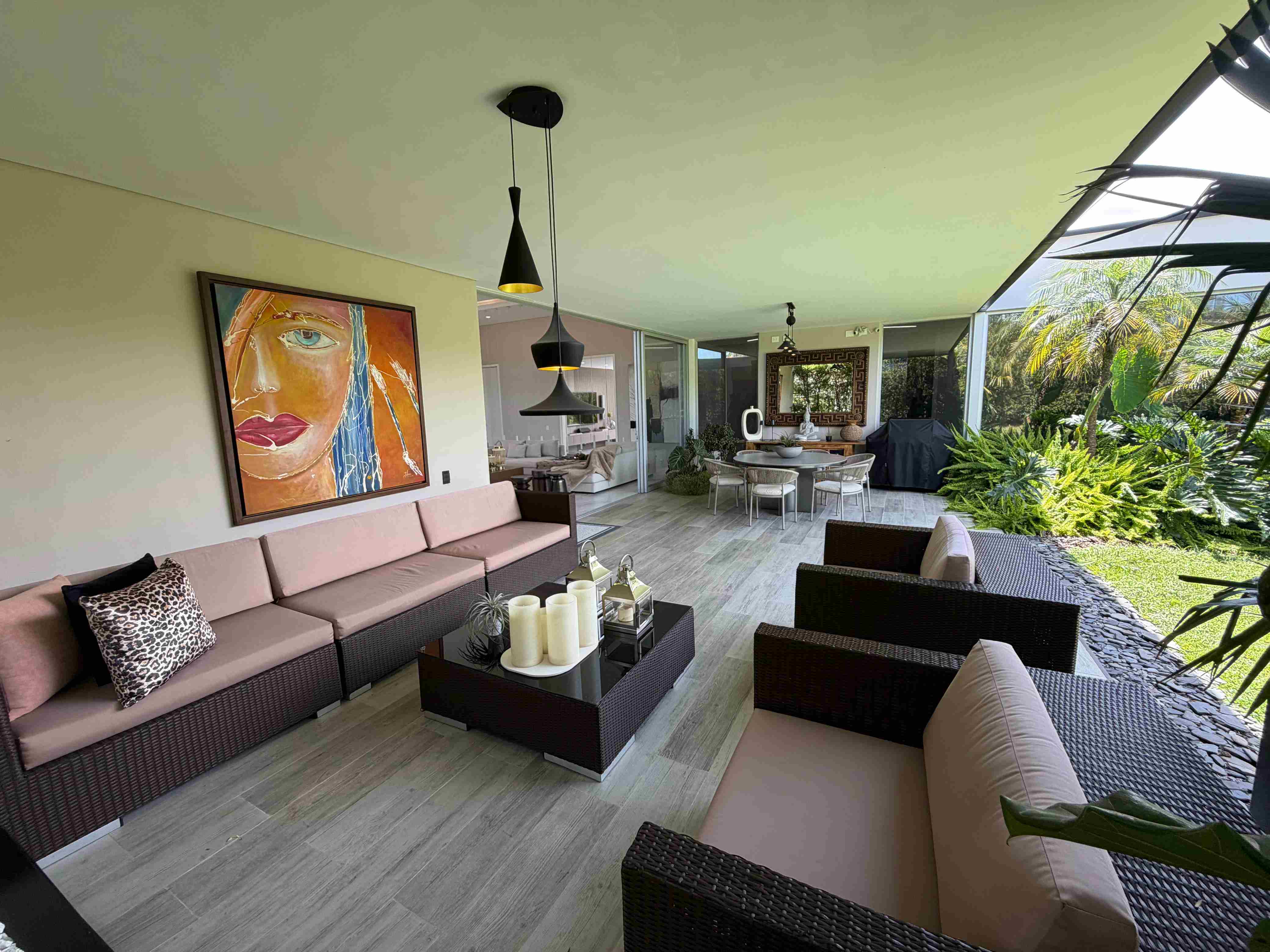 Sala lounge exterior en terraza con arte y vegetación exuberante