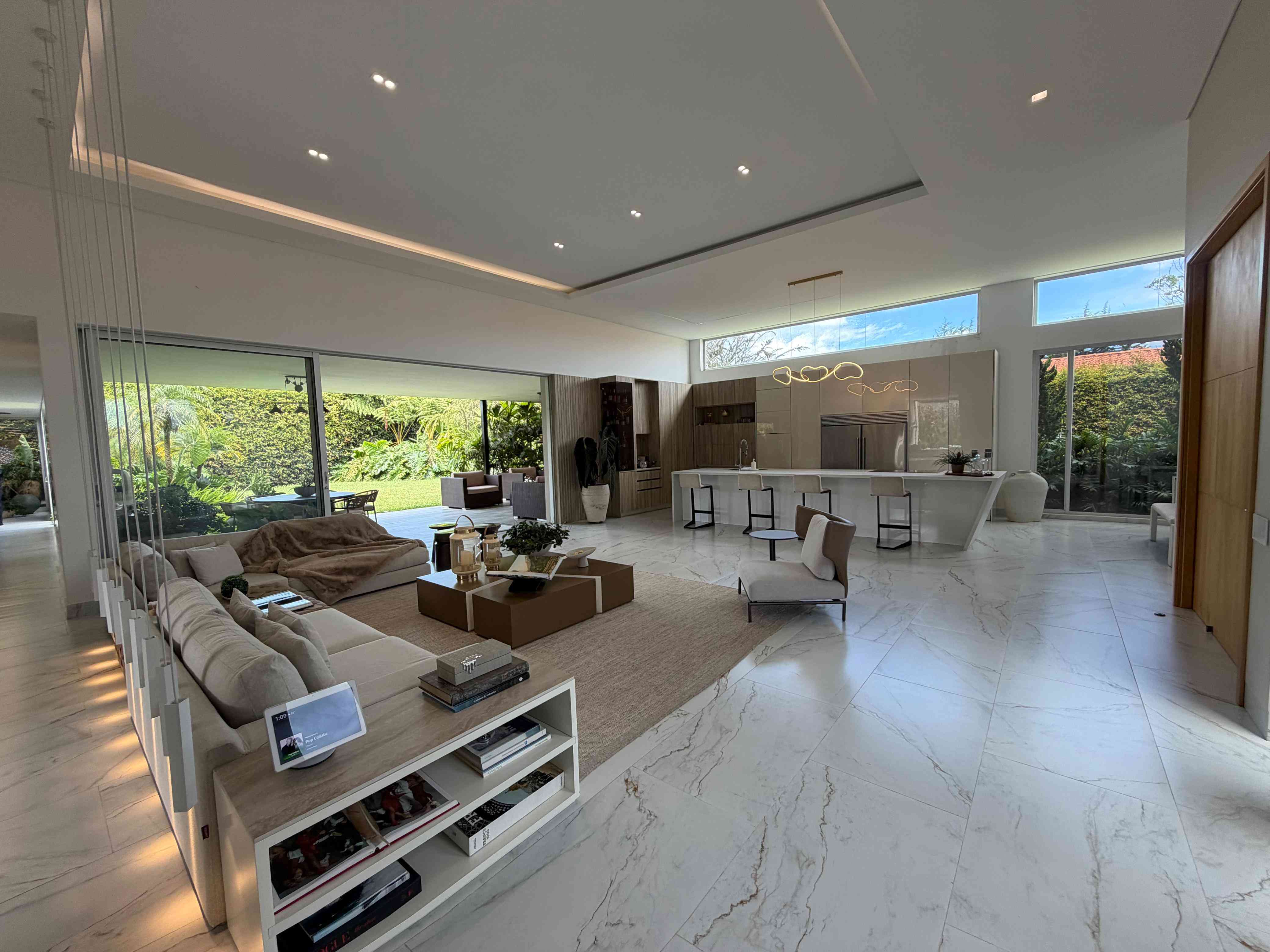 Sala a doble altura y cocina integral de Casa Campestre Sibaris con vista al jardín y terraza