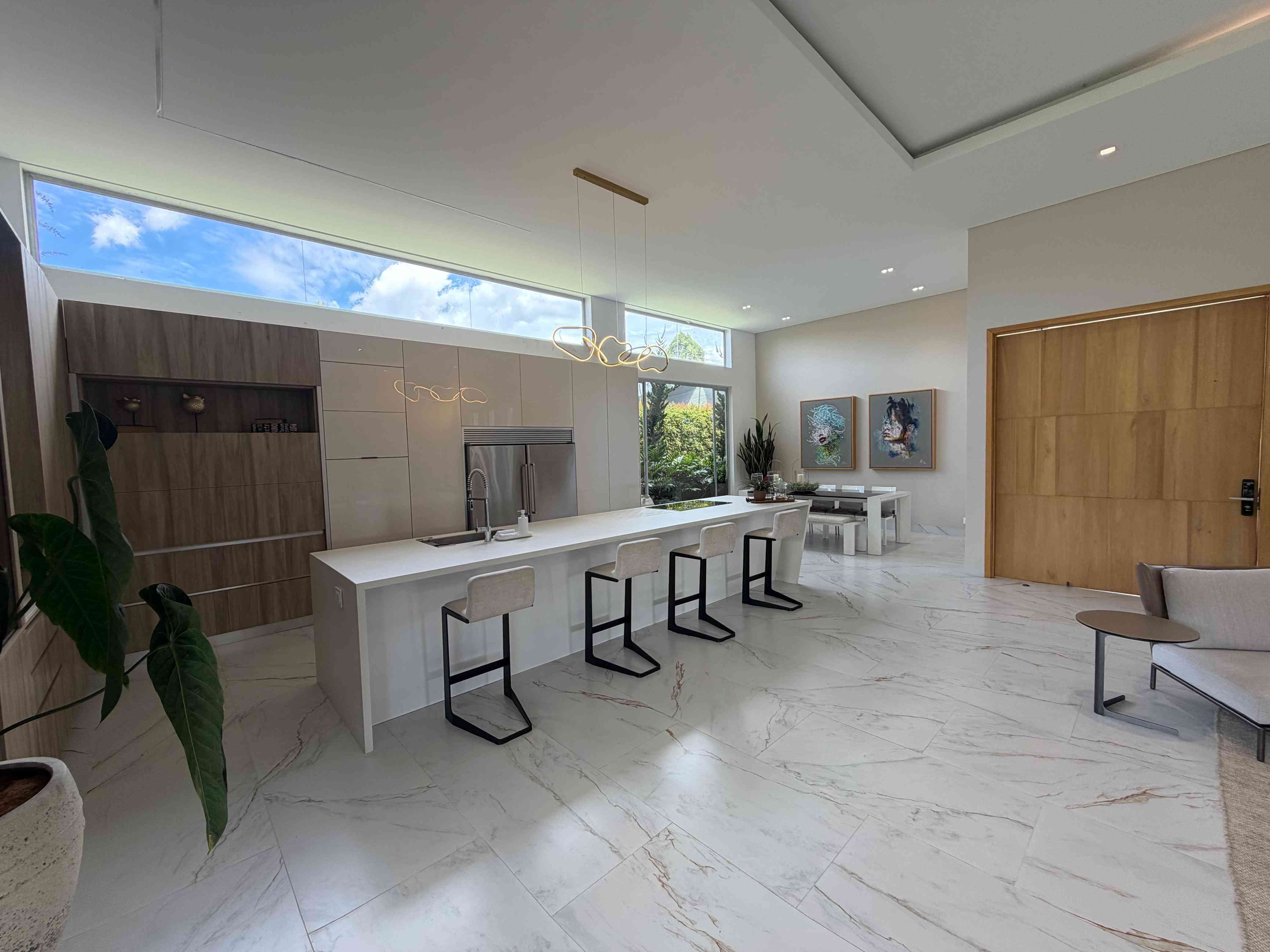 Cocina integral de diseño contemporáneo con isla central, barra y ventanal cenital