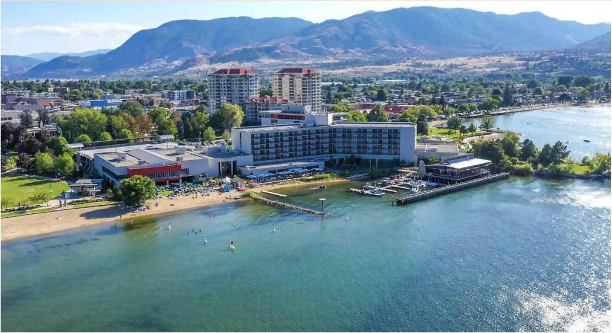 Aerial view of 86 Lakeshore building and beachfront park on Okanagan Lake