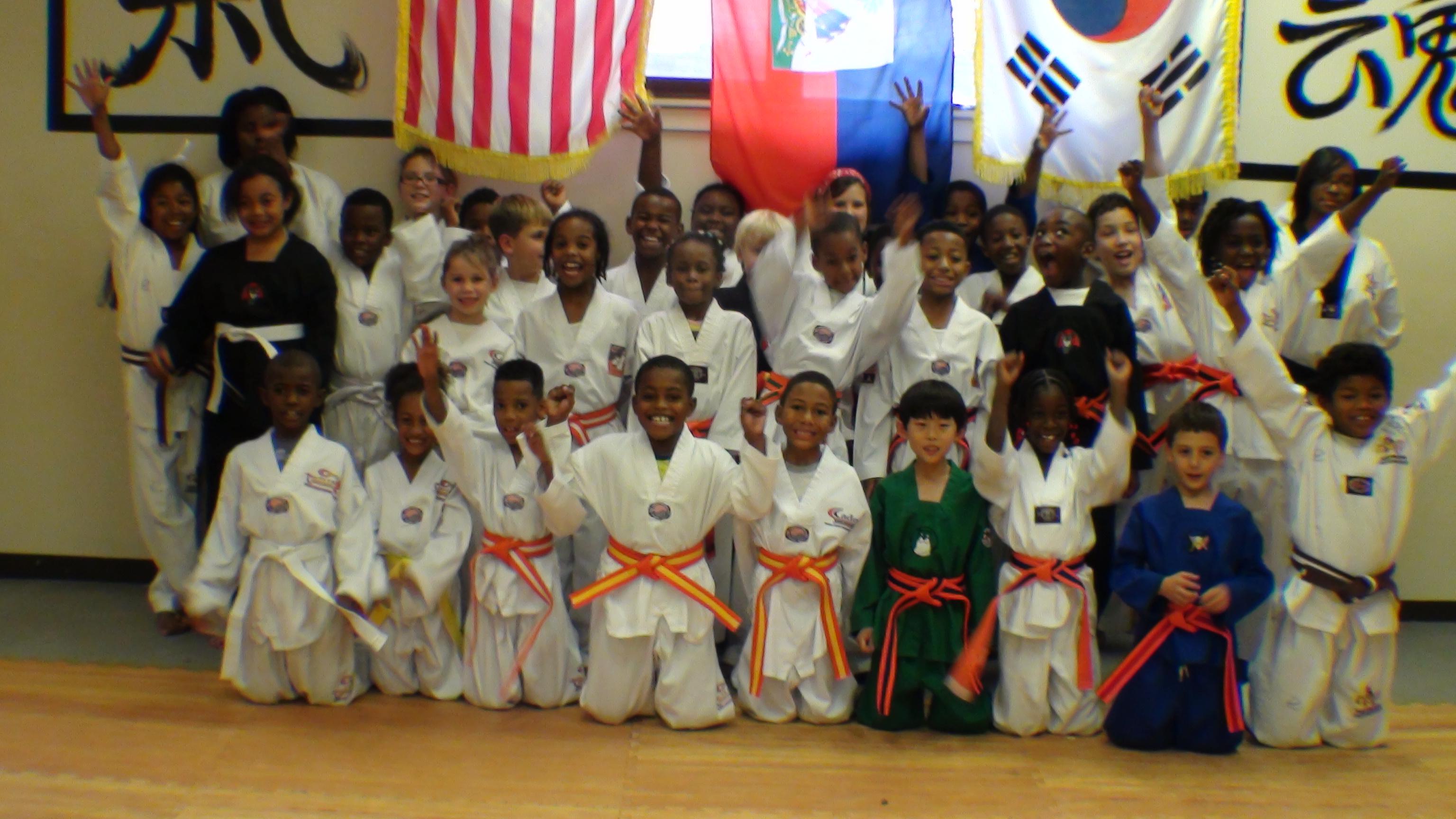 Children training martial arts forms and stances in taekwondo uniforms