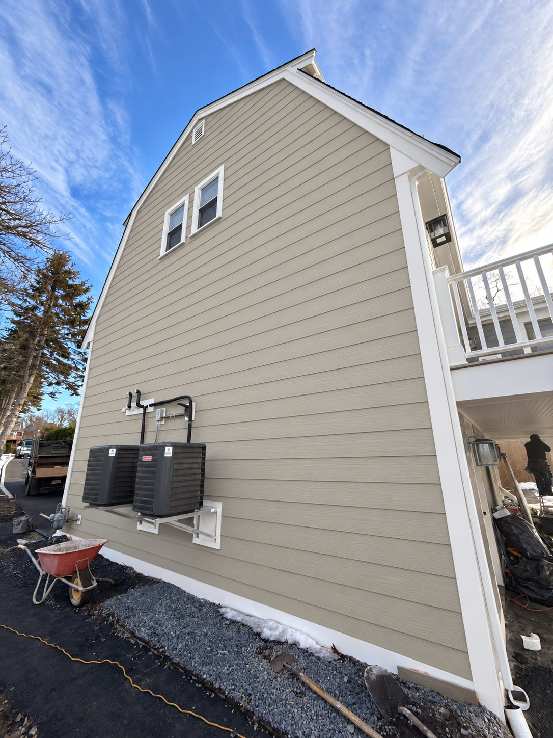 After siding installation: completed modern coastal tan siding with crisp white corner boards, architectural trim, and deck integration