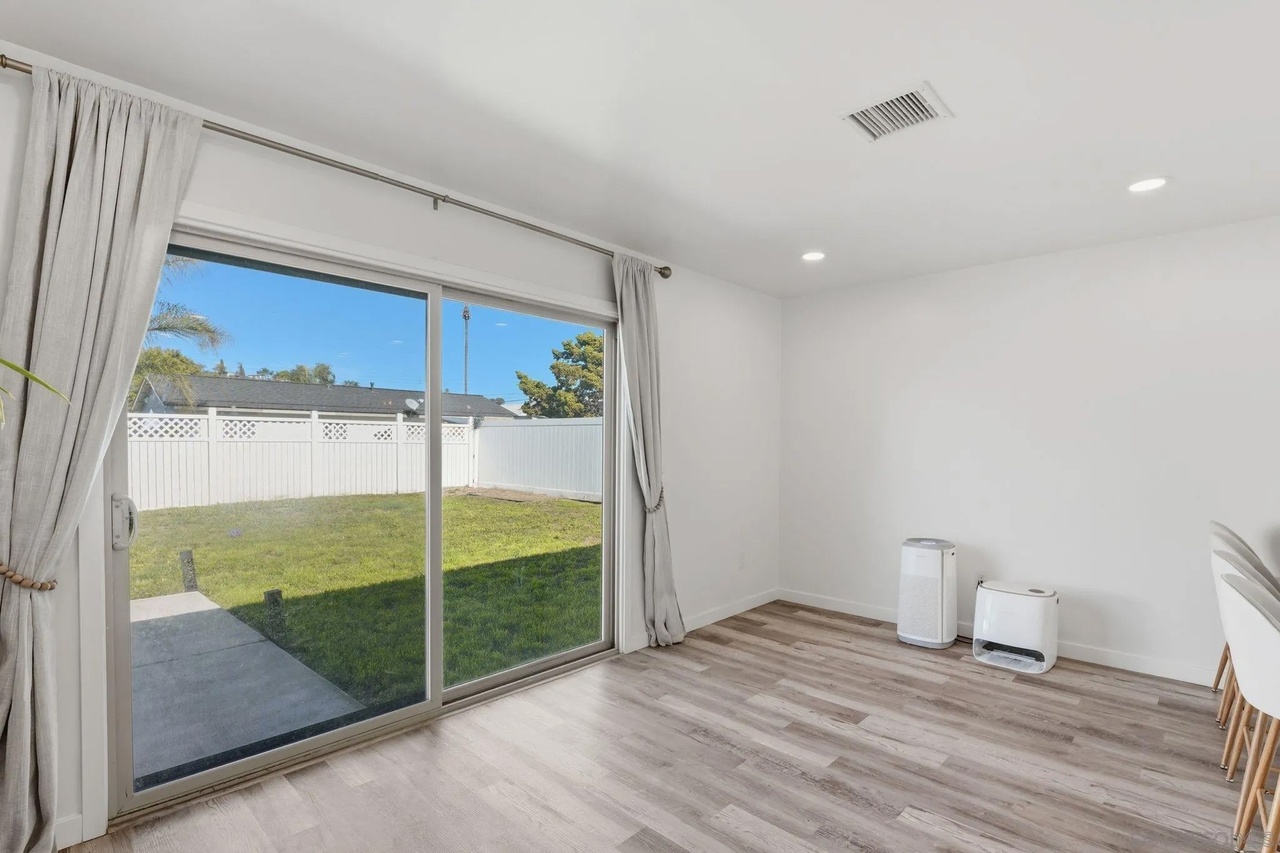 Bedroom interior with plank flooring and a window at 7742 Shorewood Drive in Skyline, San Diego, CA