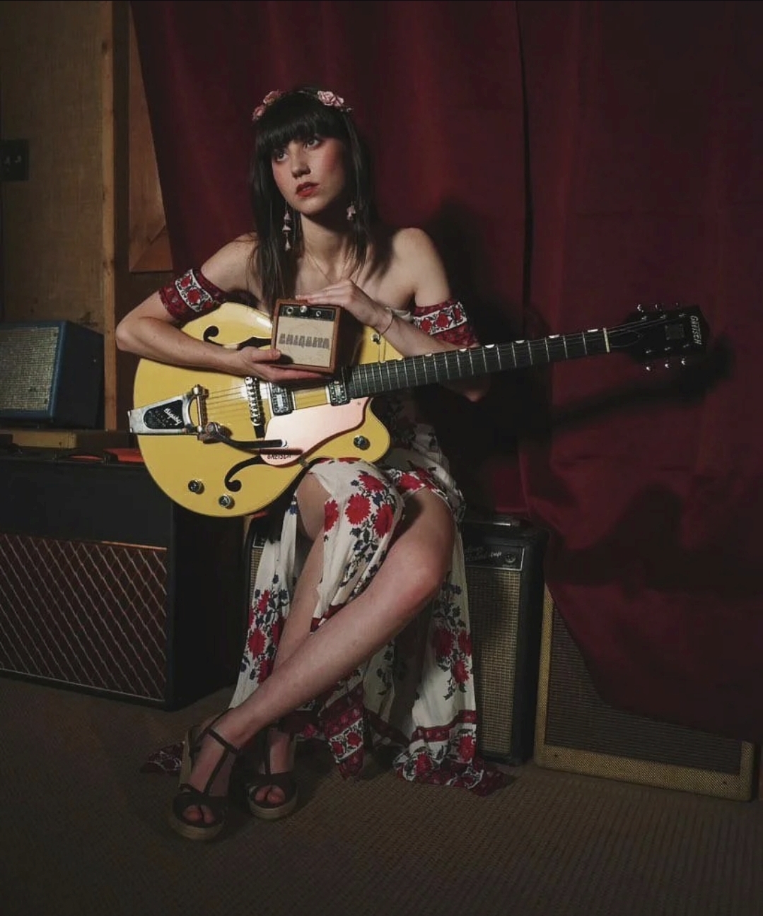 Kat Whitlock seated with yellow hollow-body electric guitar in floral dress (www.katwhitlock.com)