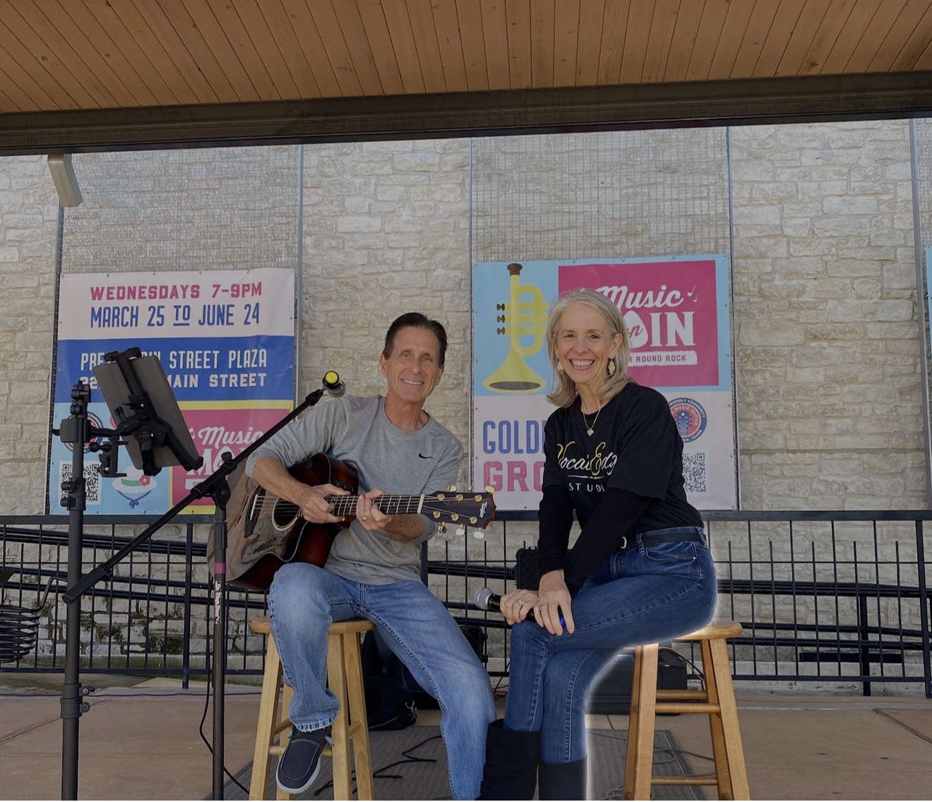 Laurie Winckel and guitarist Brian Curtis singing a duet on stage at Round Rock Market Days at Prete Main Street Plaza