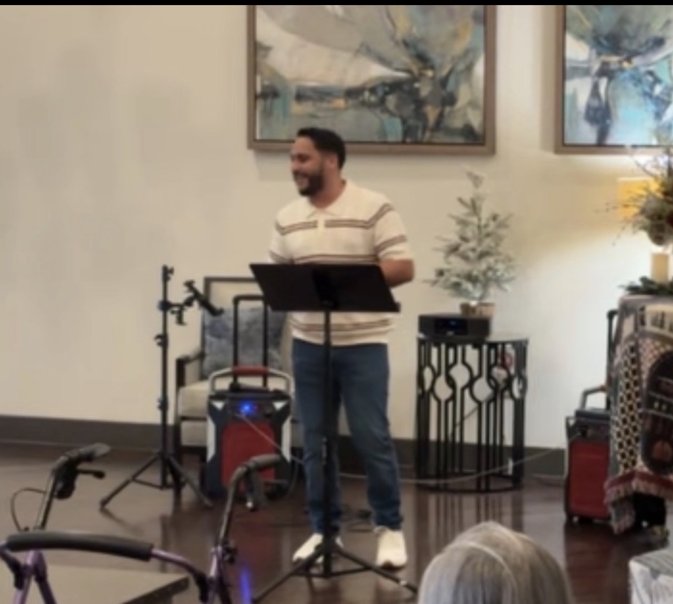 Ruben Garcia smiling while singing at the music stand and microphone