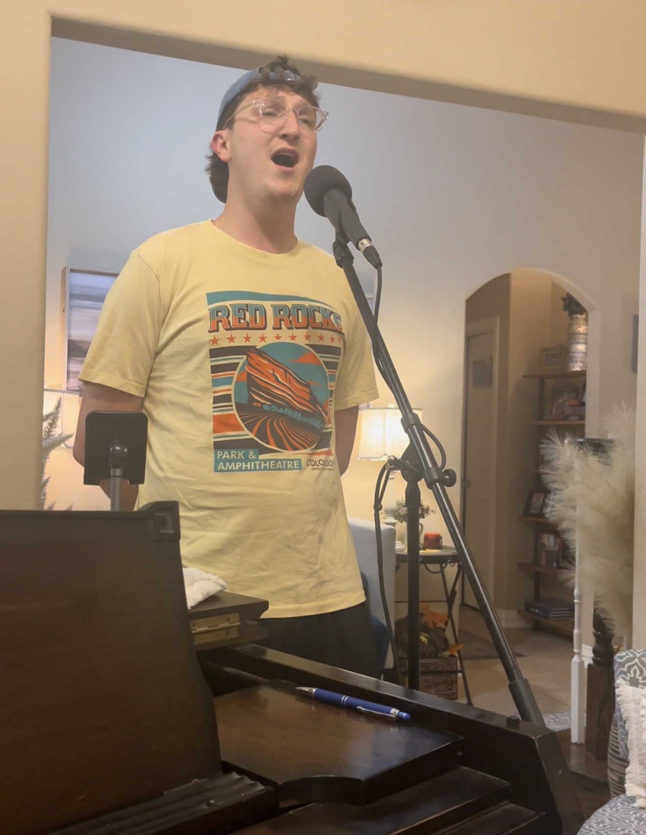 Student singing at the microphone during a private one-on-one lesson at the studio piano