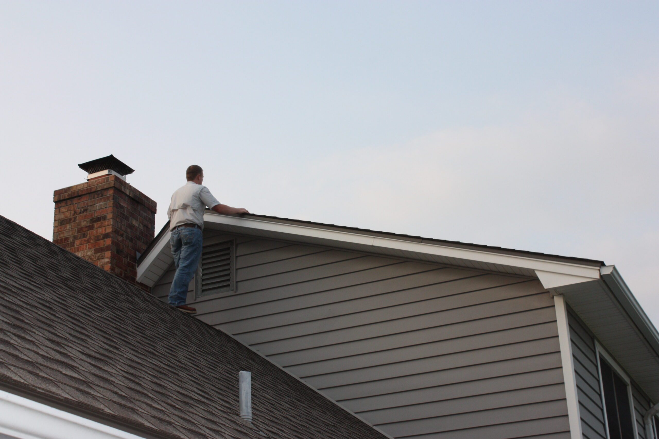 Inspector examining residential roof and chimney