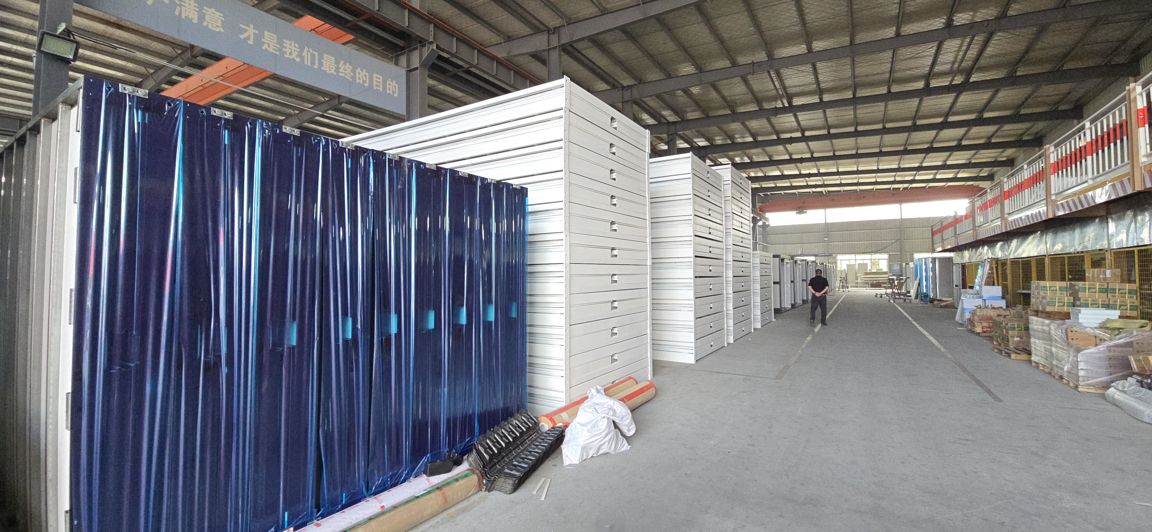 Actual stacked modular microshelters stored flat inside a warehouse staging facility