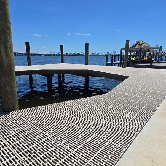 Dock with illuminated pilings and underwater night lights at dusk