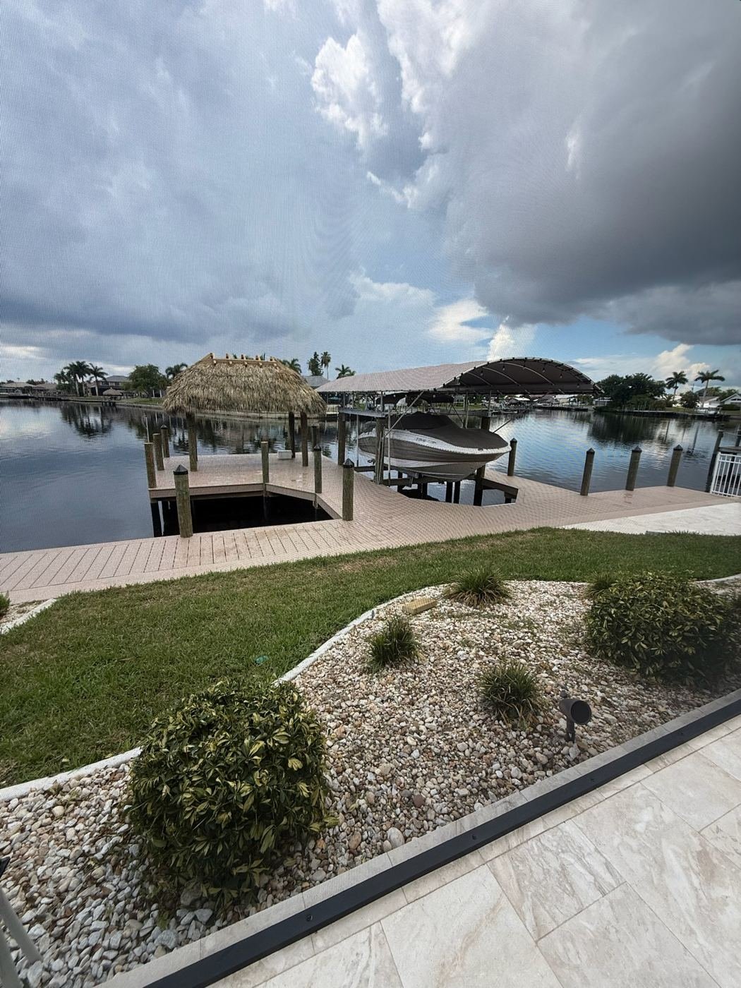 Custom vinyl dock with tiki hut and covered boat lift in Cape Coral