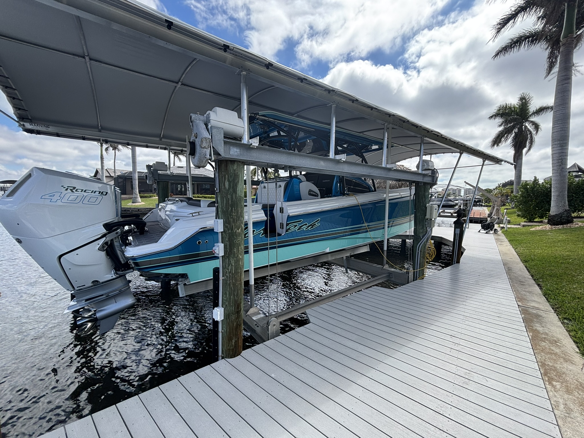 Custom boat dock with covered boat lift and composite decking in Cape Coral