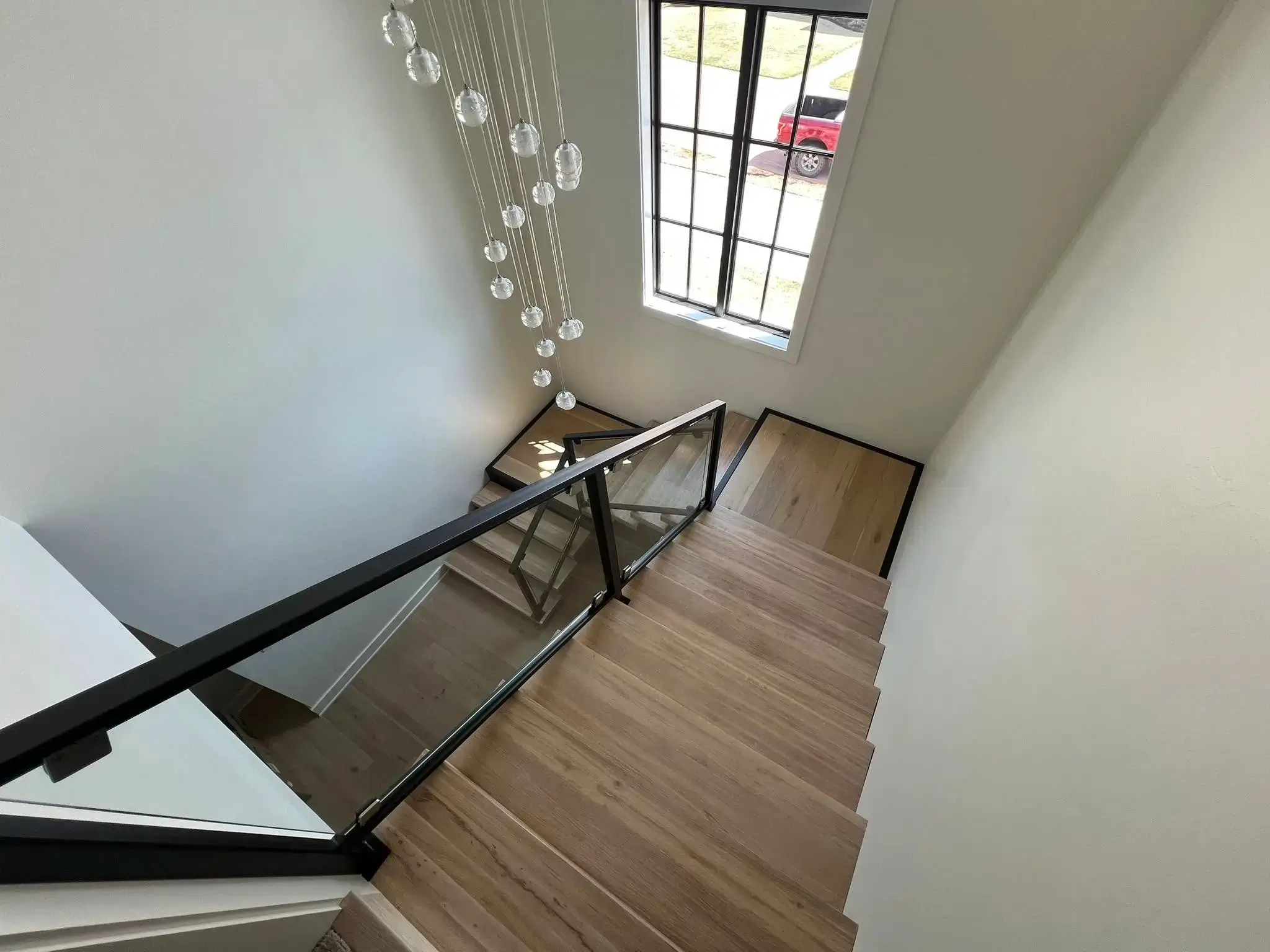 Custom hardwood stairs and glass railing installation in Stillwater OK home