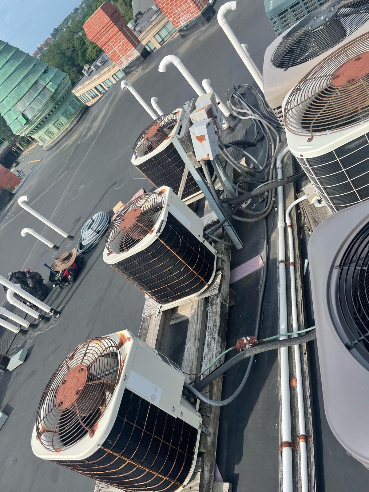 Commercial rooftop condenser unit line-up with electrical disconnects and conduit runs in Worcester MA by Prime Light Electric LLC