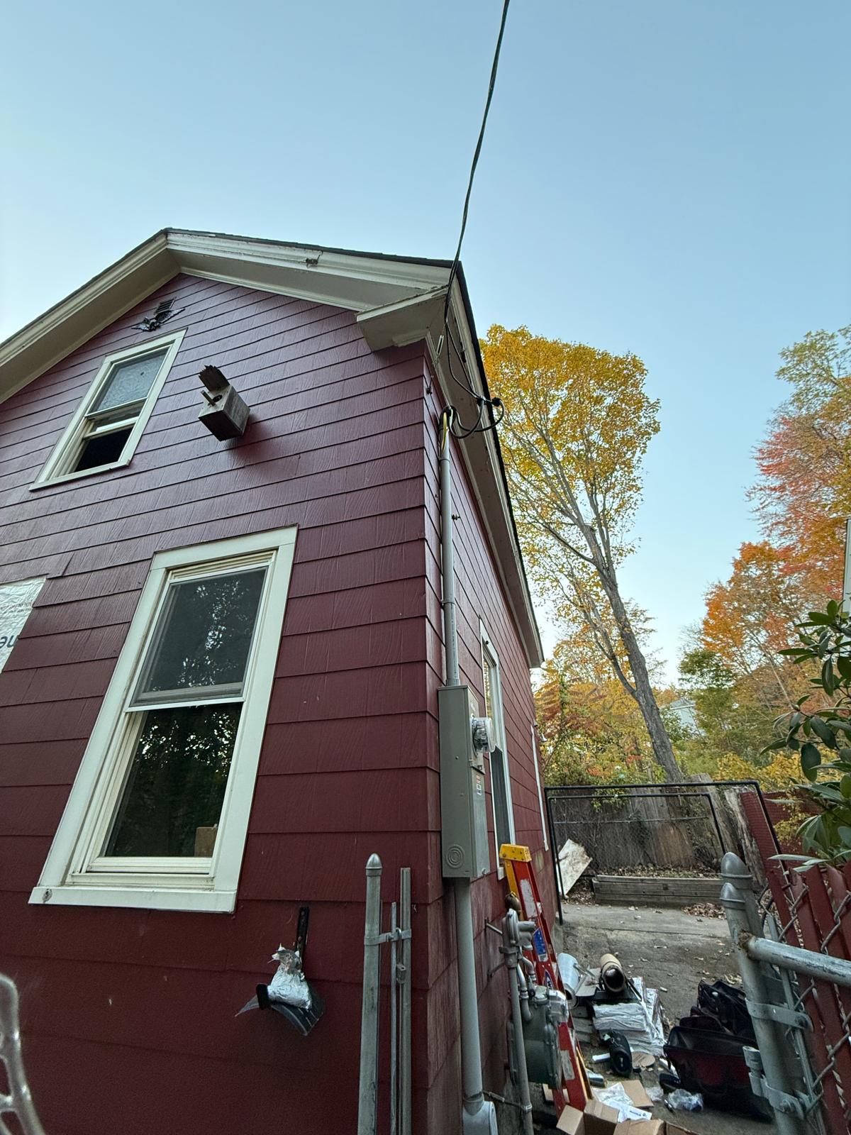 Residential exterior overhead service entrance mast, weatherhead, and meter enclosure on red wood shingle siding in Worcester MA by Prime Light Electric LLC