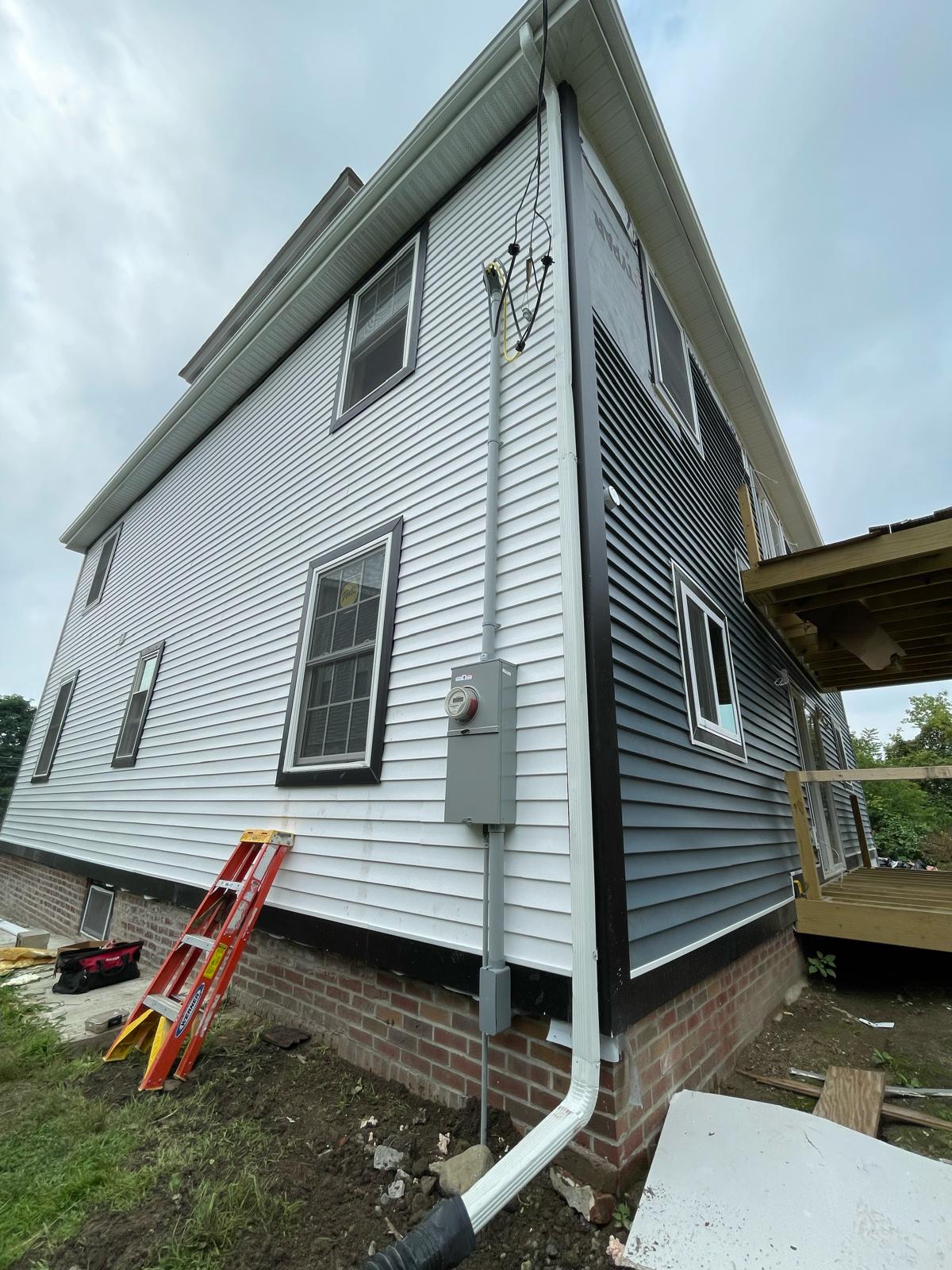 Overhead 200A electrical service entrance mast, weatherhead, and meter enclosure installed by Prime Light Electric LLC in Auburn MA