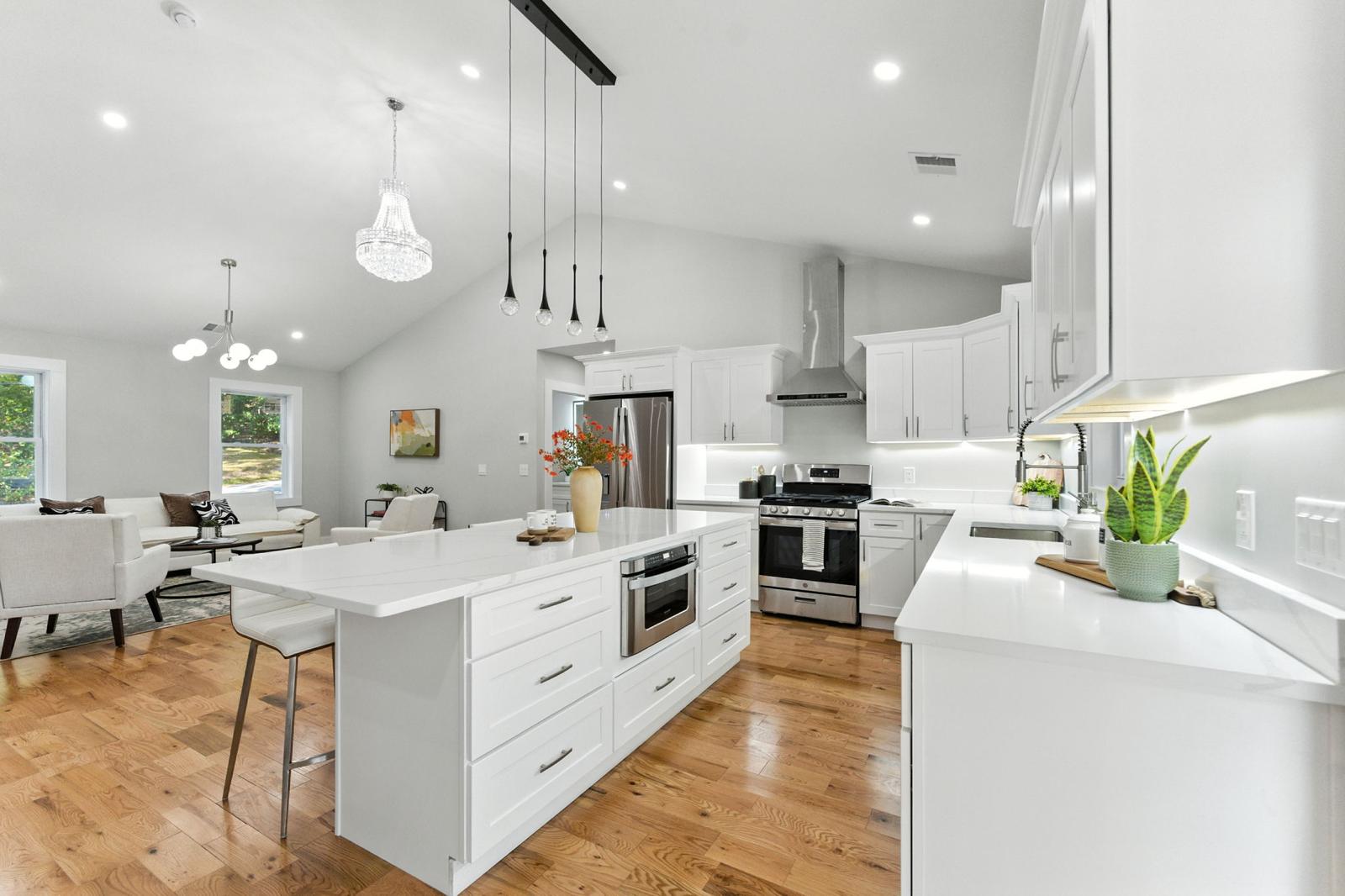 Vaulted ceiling kitchen illumination with multi-pendant island lighting and crystal chandelier by Prime Light Electric LLC in Shrewsbury MA