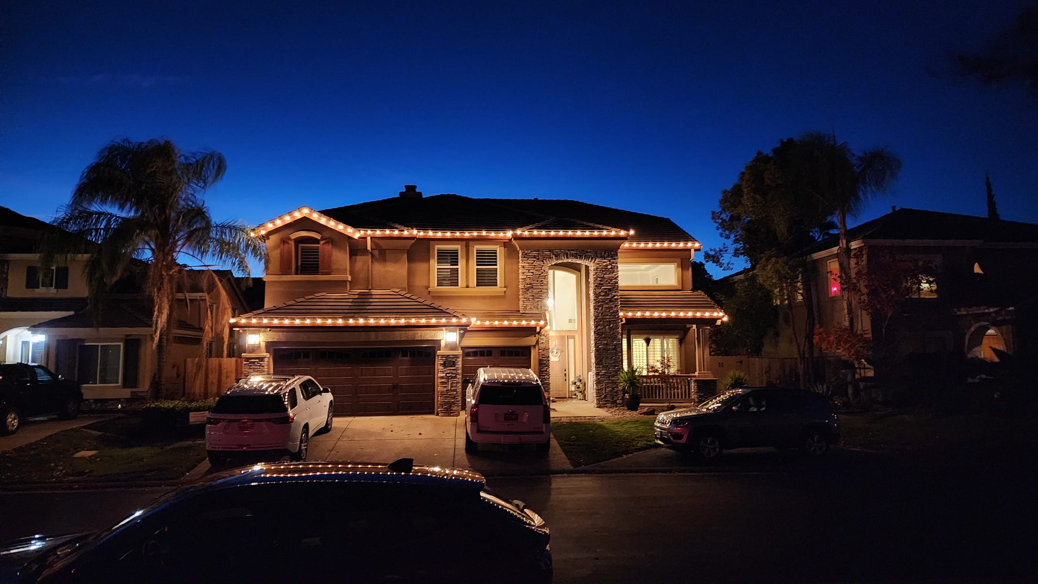Home beautifully lit with Christmas lights at dusk in Roseville CA