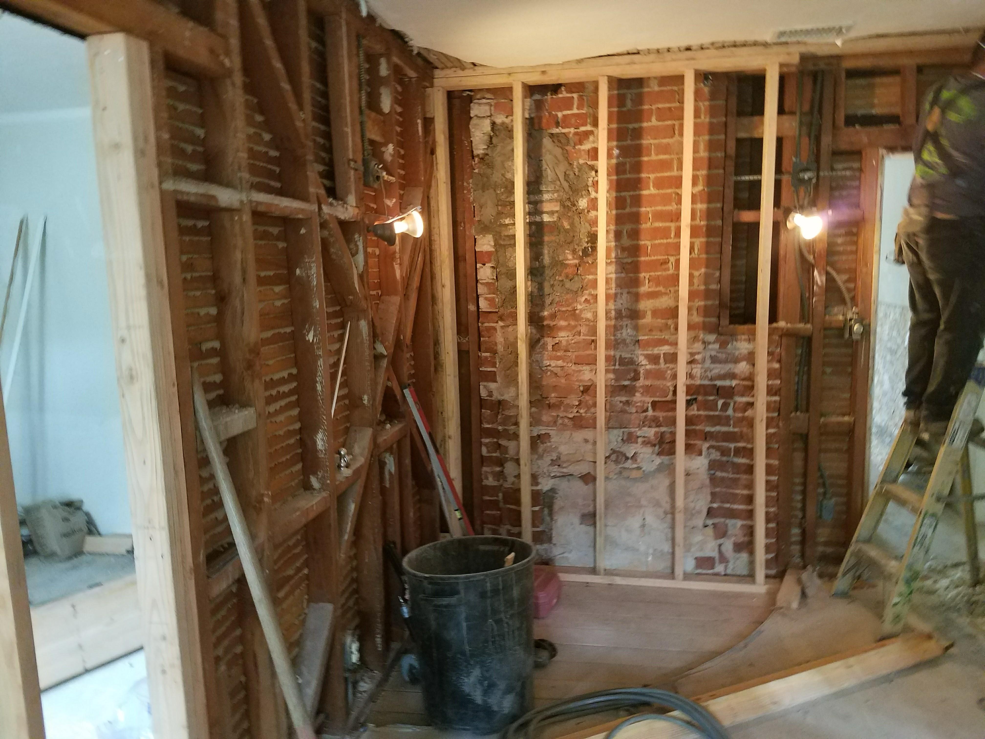 Exposed historic red brick restoration with new structural 2x4 stud wall framing and electrical rough-in by LA Builder Construction