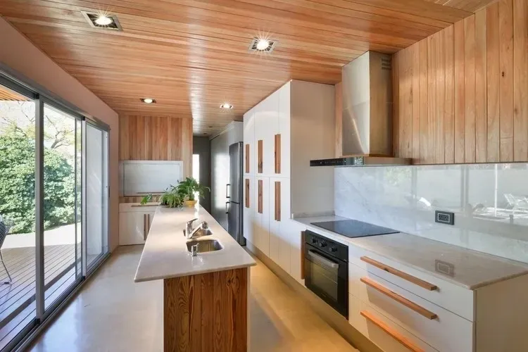 Custom contemporary kitchen with wood paneling and waterfall island
