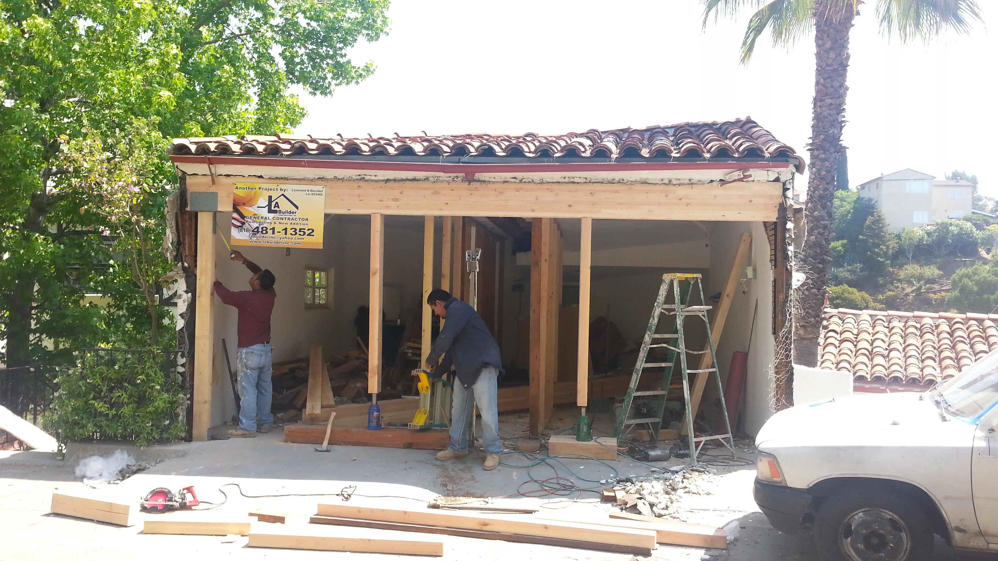 LA Builder Construction crew installing heavy wood structural header beam and post shoring for a garage ADU conversion in Van Nuys, CA