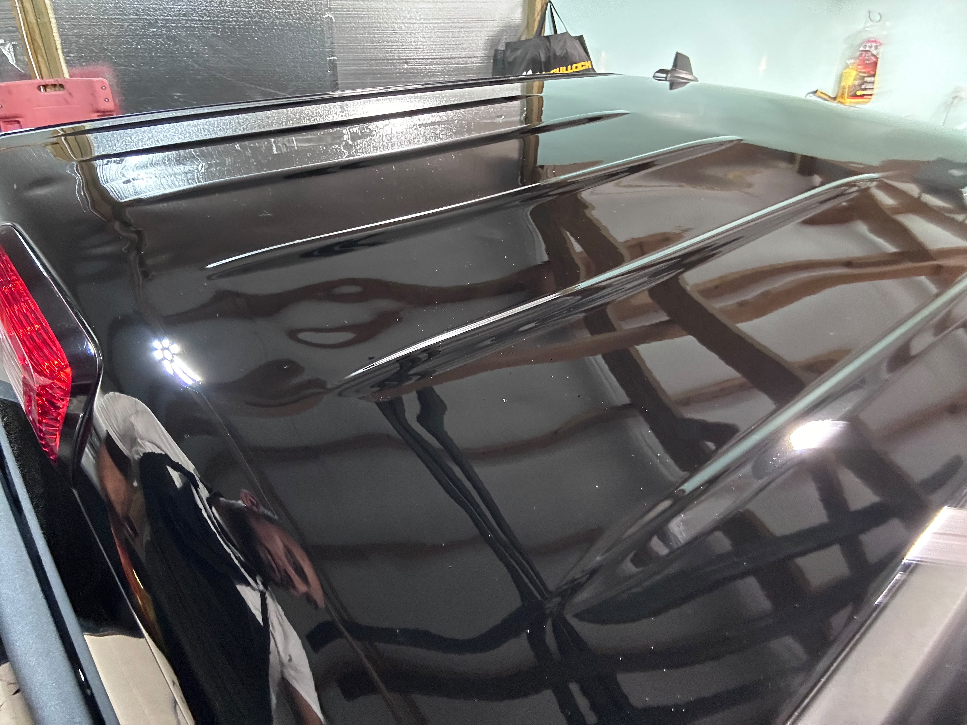 Mirror gloss black vehicle roof after multi-stage compound paint correction and water spot removal by Miracle Detailing Lindon UT