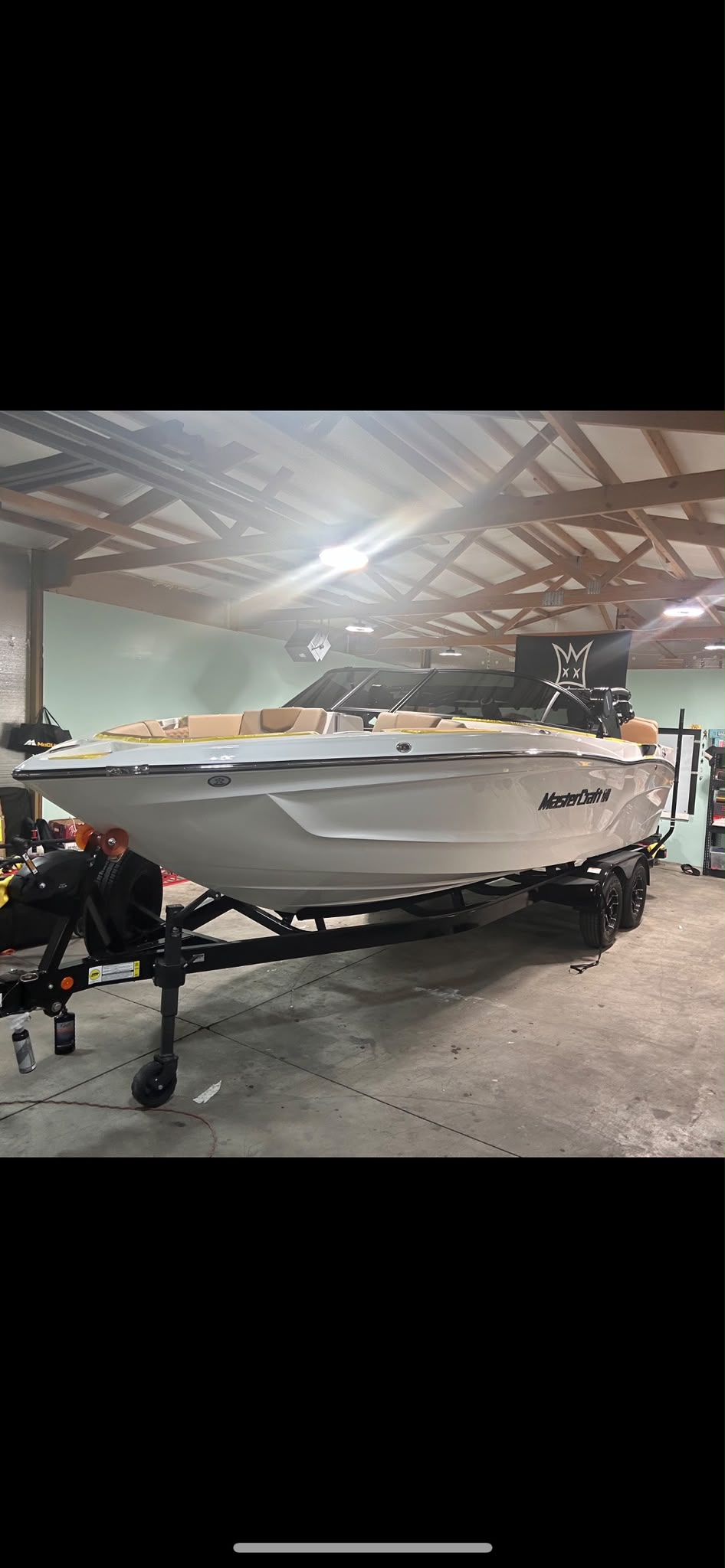 MasterCraft luxury wakeboard boat masked and ready for gelcoat compound polish and ceramic protection in shop bay by Miracle Detailing