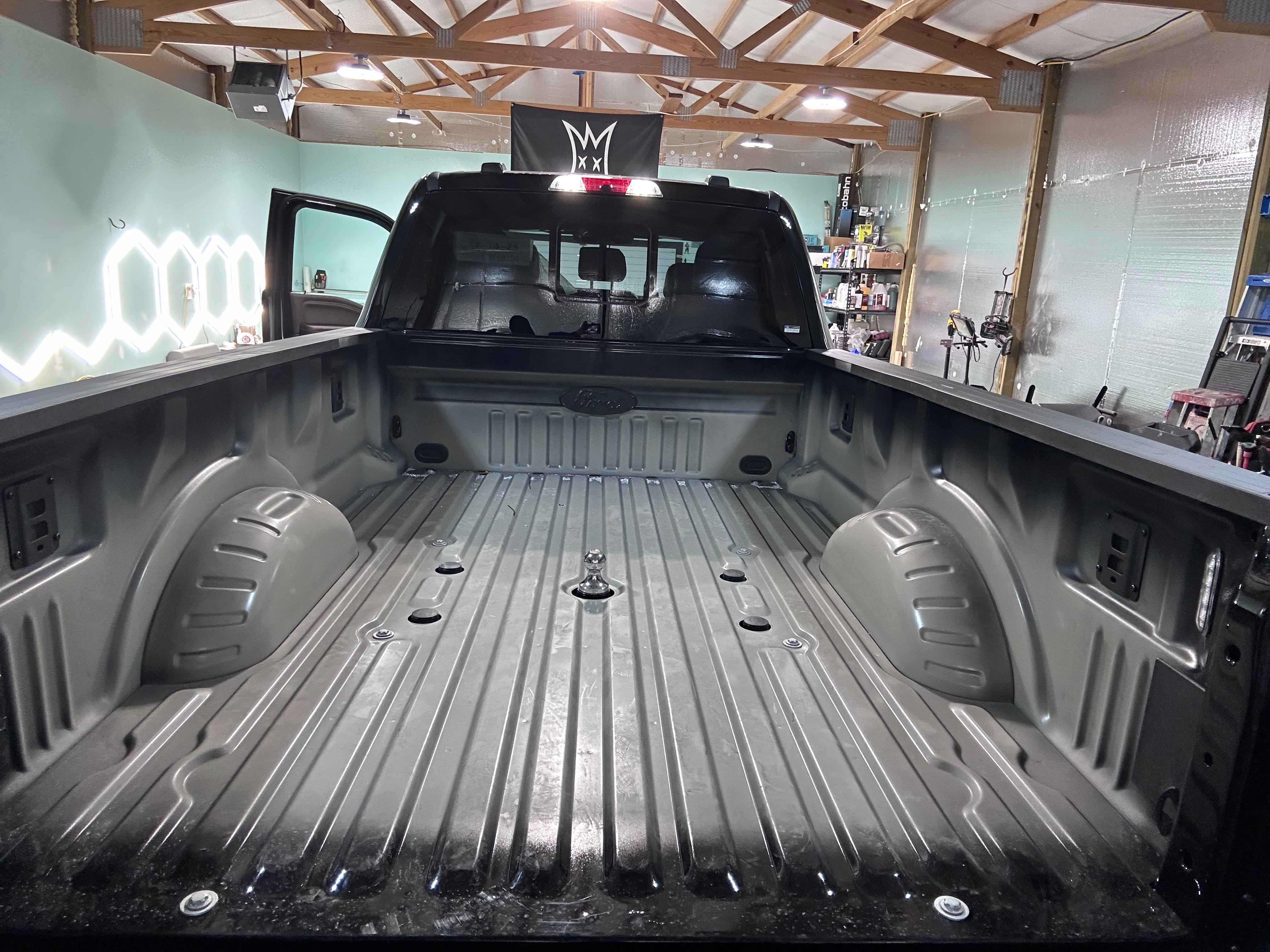 Ford Super Duty truck bed fully prepped and scuffed in detail bay under LED lights for spray-in Rhino Lining application by Miracle Detailing Lindon UT