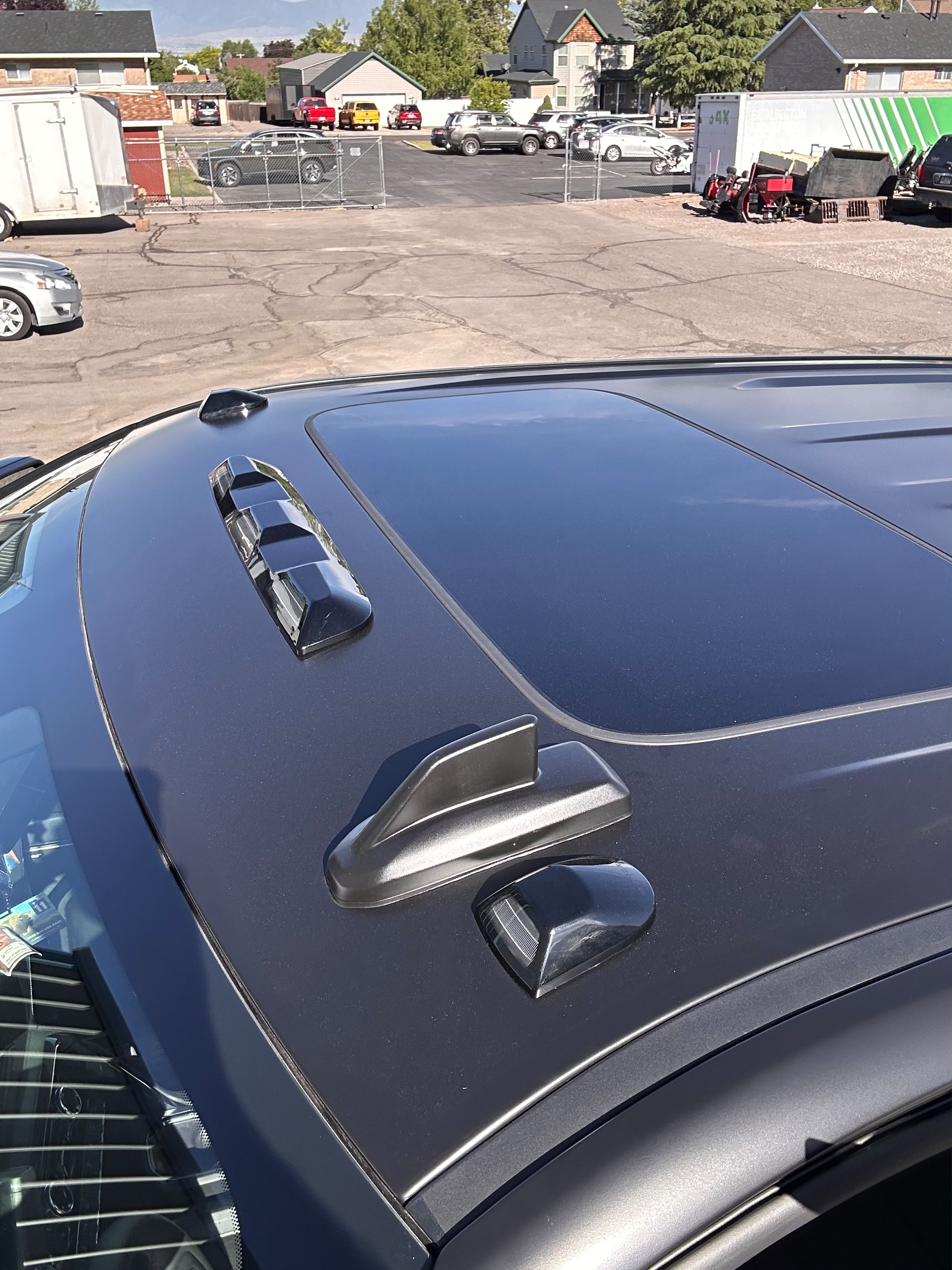 Completed satin black roof vinyl wrap around sunroof and cab marker lights outdoor sunlight inspection by Miracle Detailing