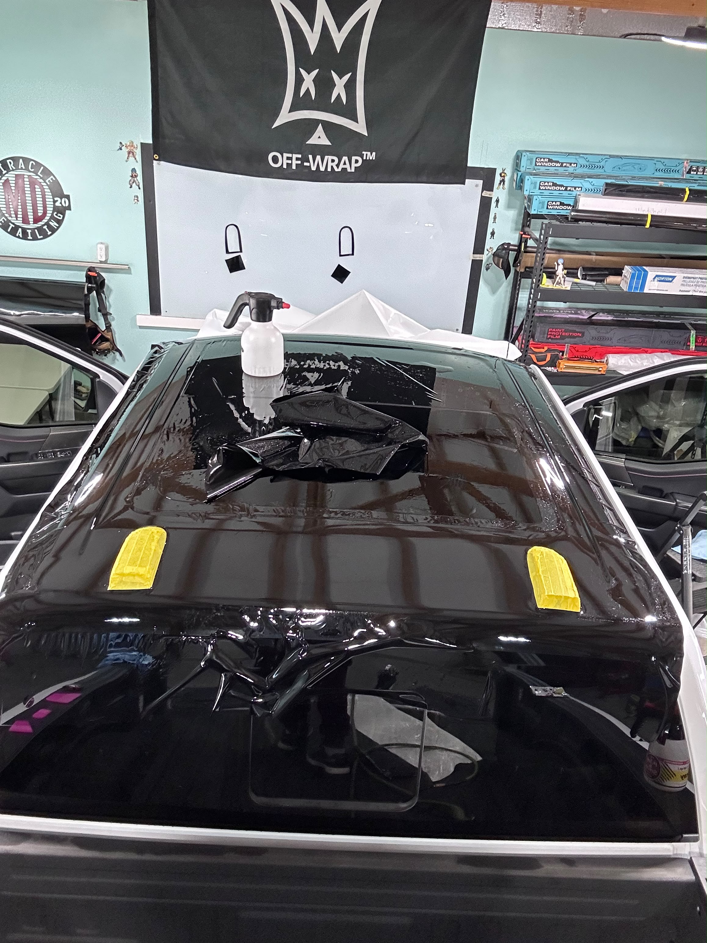 Truck roof vinyl wrap install with precision slip solution and squeegee technique in shop by Miracle Detailing
